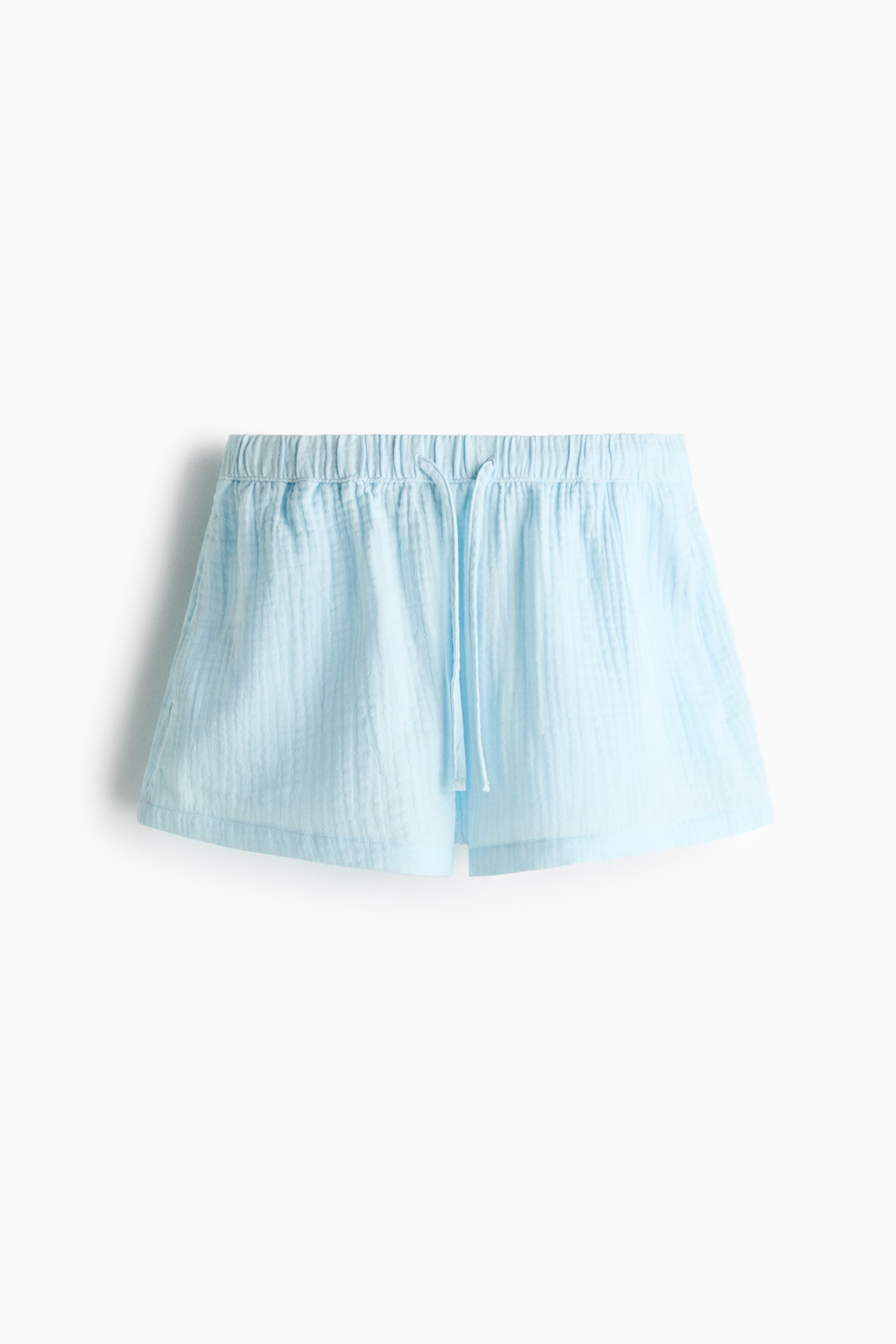 Voir une image plus grande: Les shorts bleu clair à coupe ample mettent en valeur un tissu en mousseline de coton aéré, avec une taille élastiquée à cordon de serrage et des poches latérales discrètes.