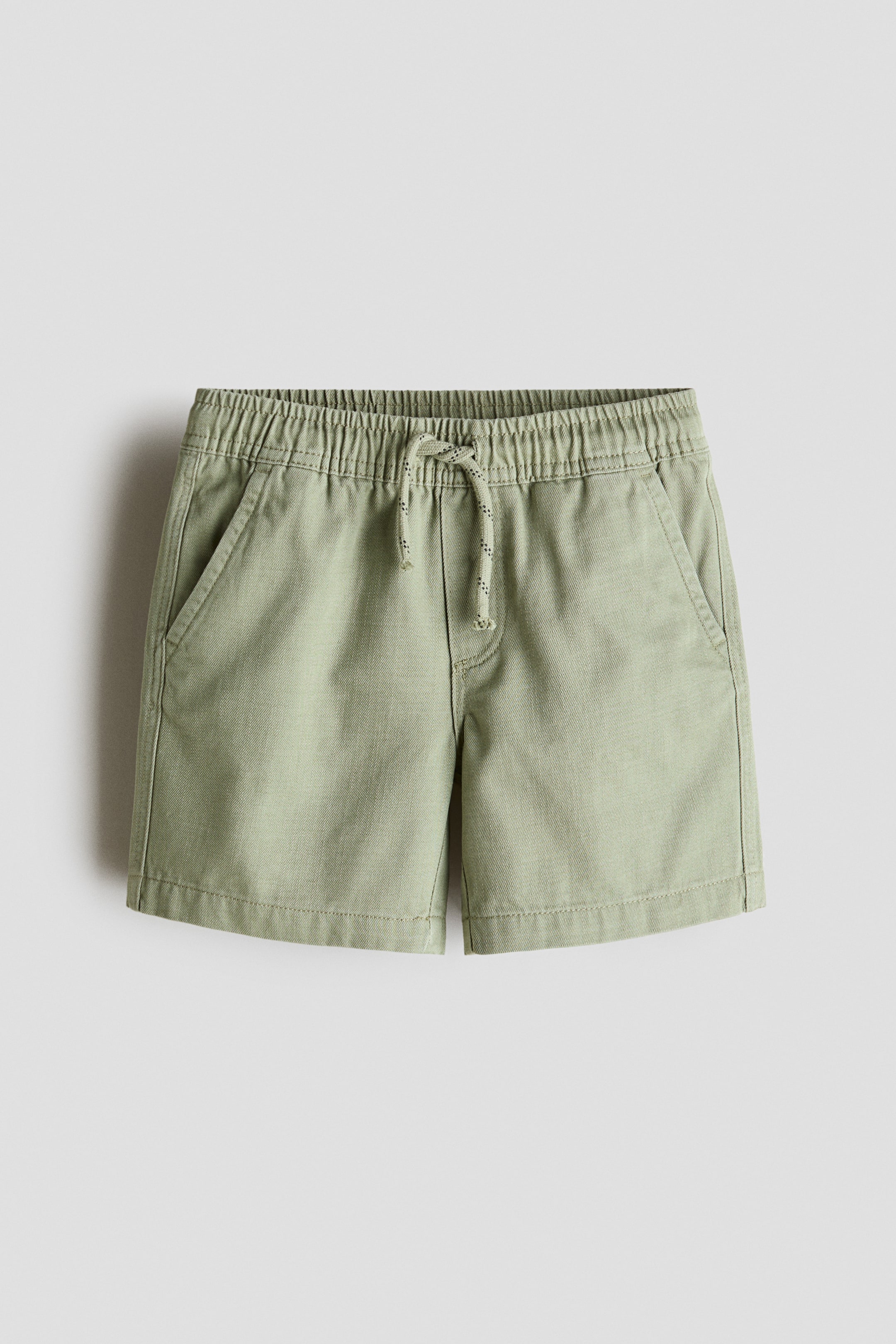 Ver imagen más grande: Pantalones cortos a la altura de la rodilla en tejido de algodón verde claro, presentados de frente, con cintura elástica y cordón ajustable, bragueta falsa y bolsillos laterales diagonales.