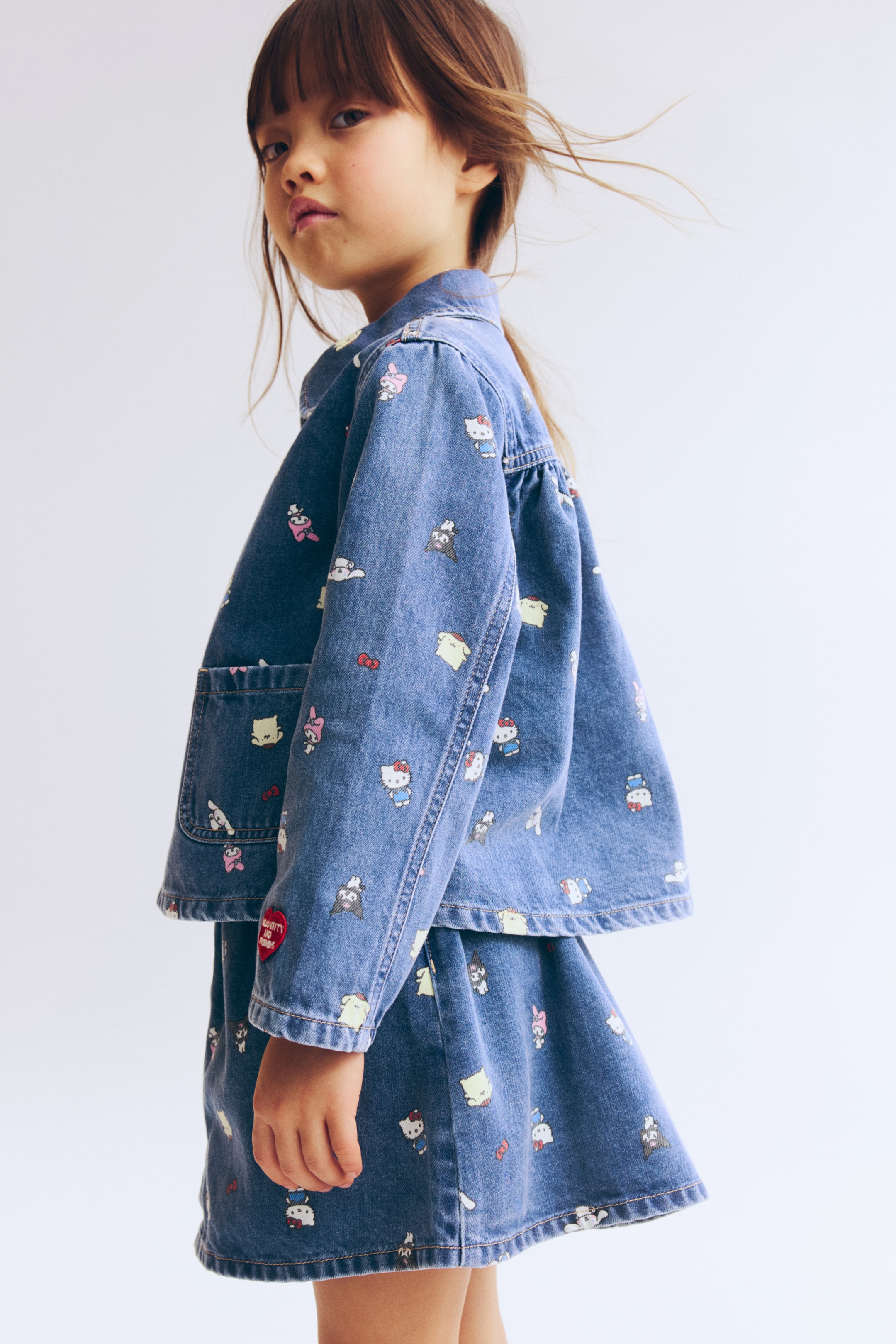 View larger image: A soft cotton denim jacket, presented from the FRONT, is showcasing an all-over print, a rounded collar, and snap buttons down the front. It is also featuring a patch front pocket and a back yoke with gathers.