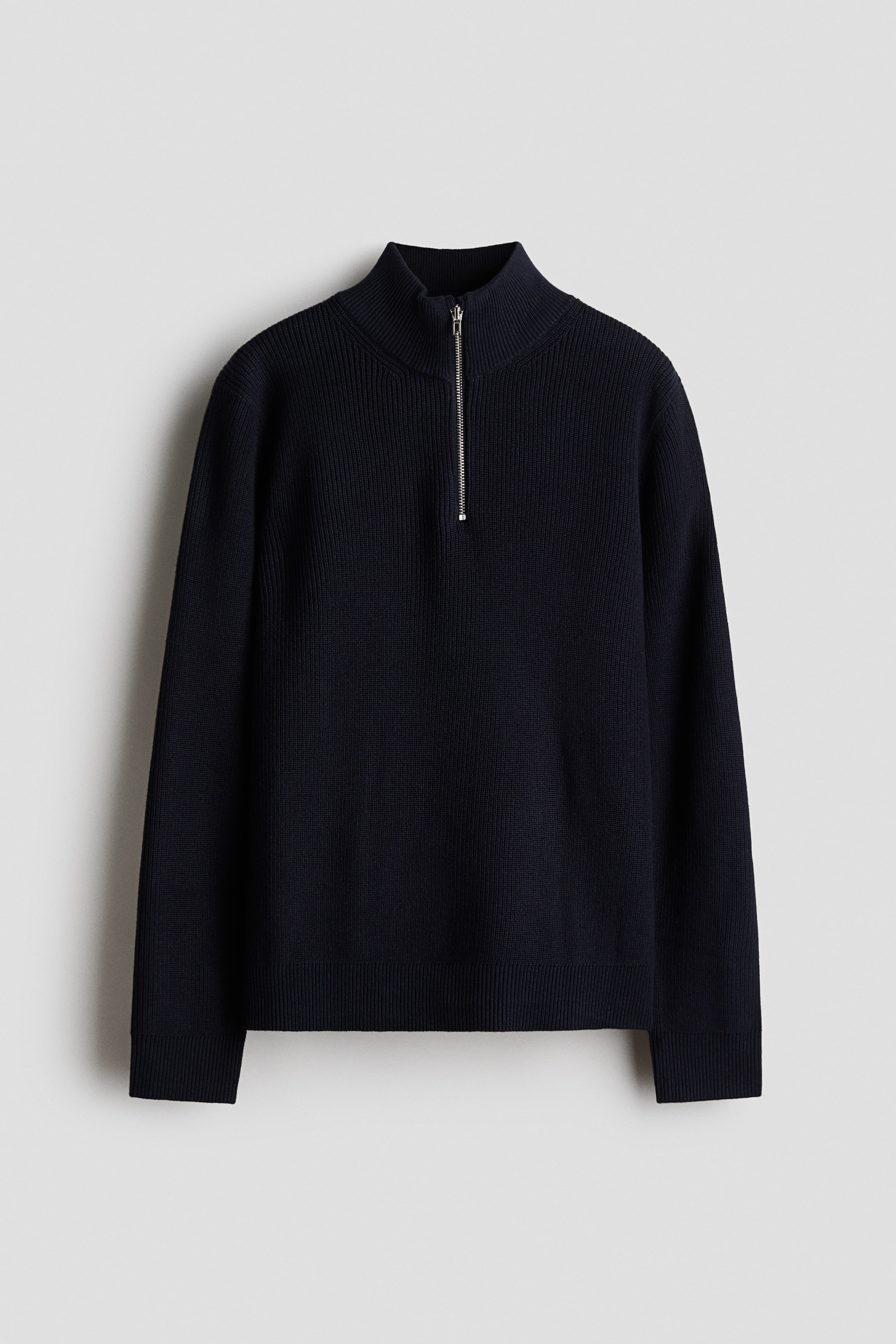 View larger image: A dark blue quarter-zip sweater is facing forward, featuring a standing ribbed collar with a silver-toned zipper extending down the chest. It is displaying ribbed cuffs and a ribbed hem.