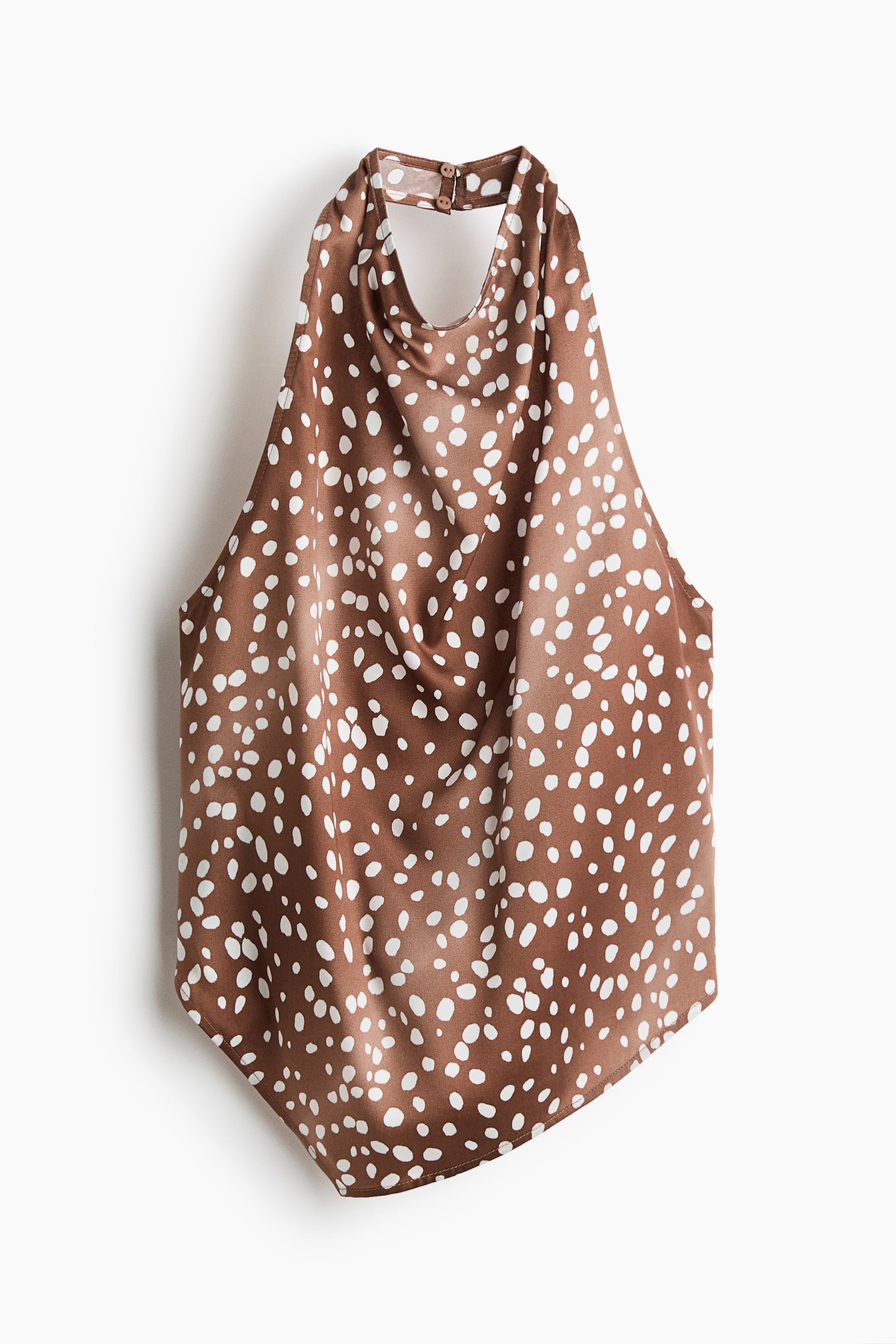Voir une image plus grande: Un haut licou brun à motif de taches blanches est suspendu en vue de face, mettant en valeur un décolleté drapé de type cowl et un col montant avec fermetures à boutons. Le haut est confectionné dans un tissu lisse, semblable au satin, et présente un ourlet asymétrique.