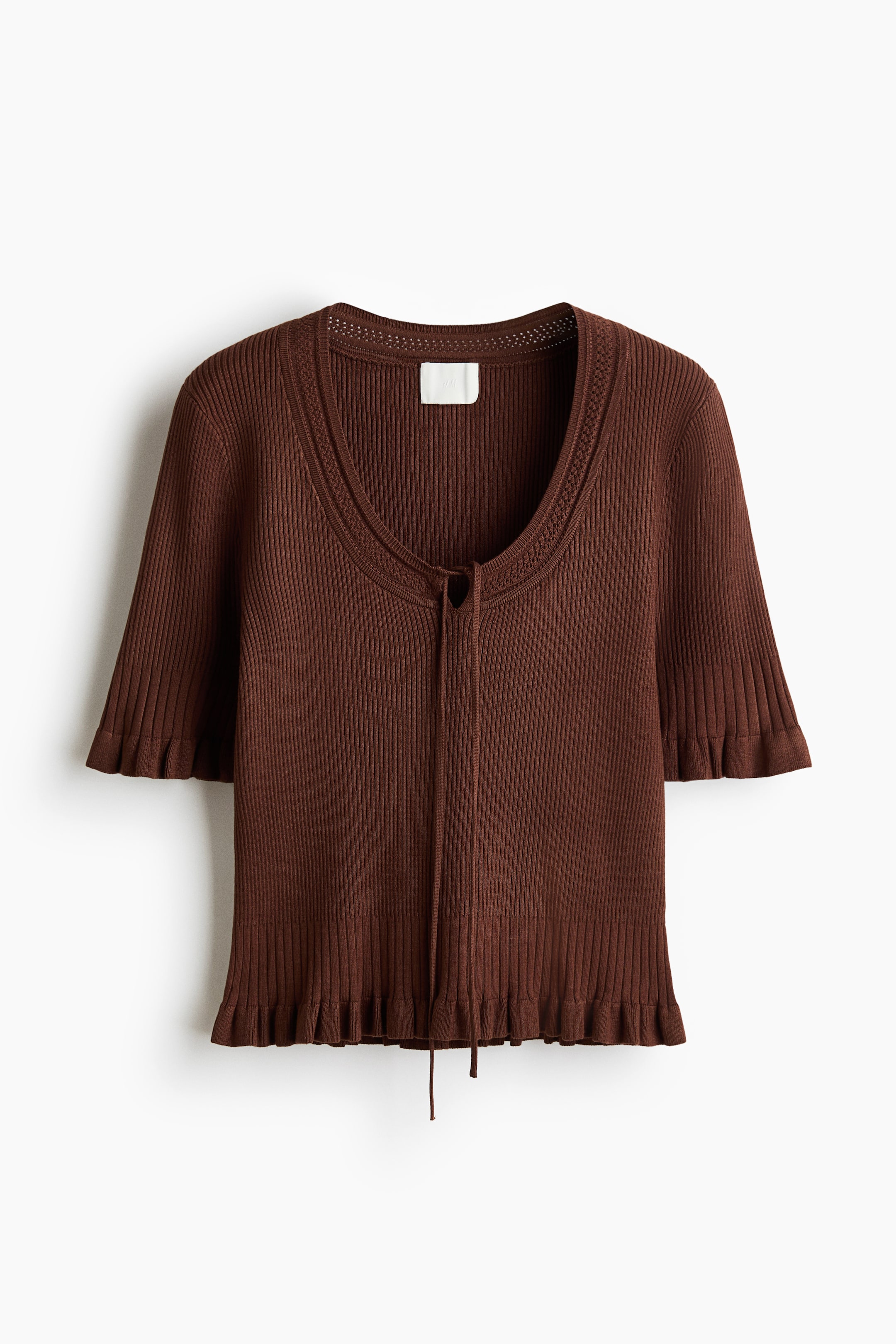 View larger image: The image showcases a brown short-sleeved top viewed from the front. It features a fine rib knit, a pointelle-knit scoop neckline with a keyhole opening, and narrow ties at the front. Frill trims detail the cuffs and hem, adding a touch of elegance.