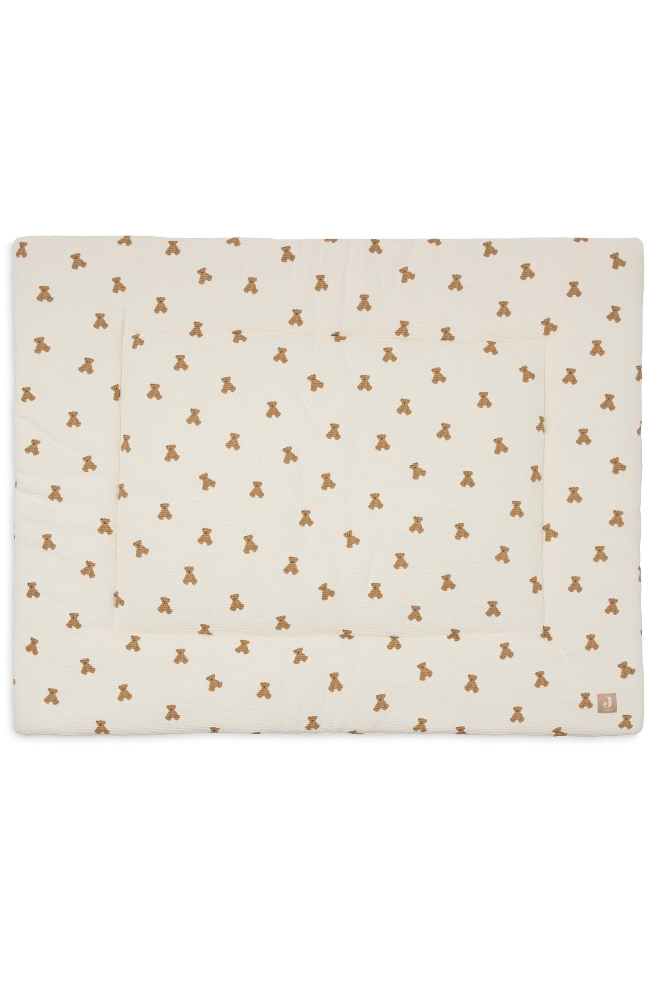 Größeres Bild ansehen: Eine rechteckige, cremefarbene gepolsterte Spielmatte zeigt ein sich wiederholendes Muster aus kleinen braunen Teddybären. Die Matte verfügt über einen genähten rechteckigen Rand, der von den Kanten nach innen versetzt ist, sowie über ein kleines quadratisches Logo-Label in der unteren rechten Ecke.
