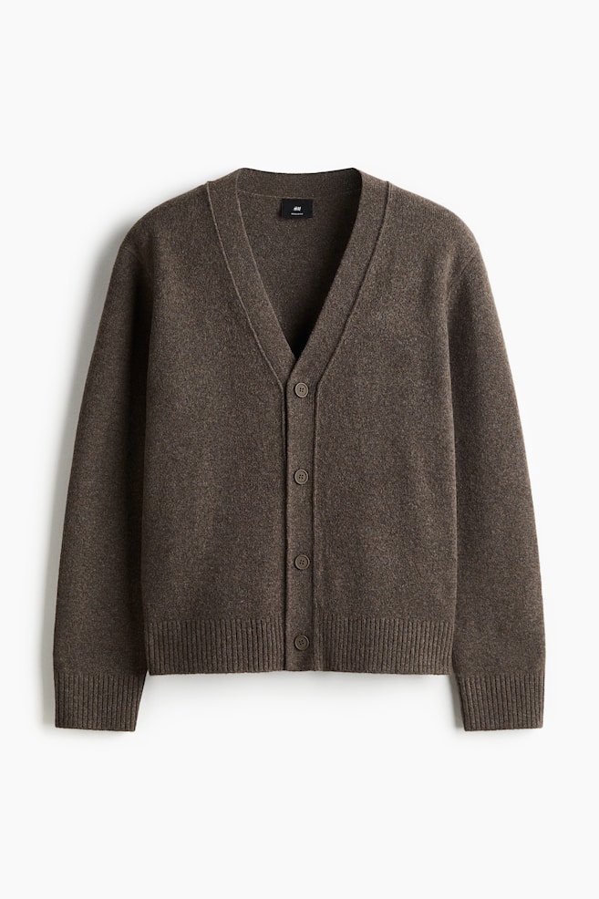 Eine braune, strukturierte Strickjacke mit V-Ausschnitt wird von vorne gezeigt. Sie verfügt über einen Knopfverschluss mit fünf passenden Knöpfen, gerippten Bündchen und einem gerippten Saum. - 1