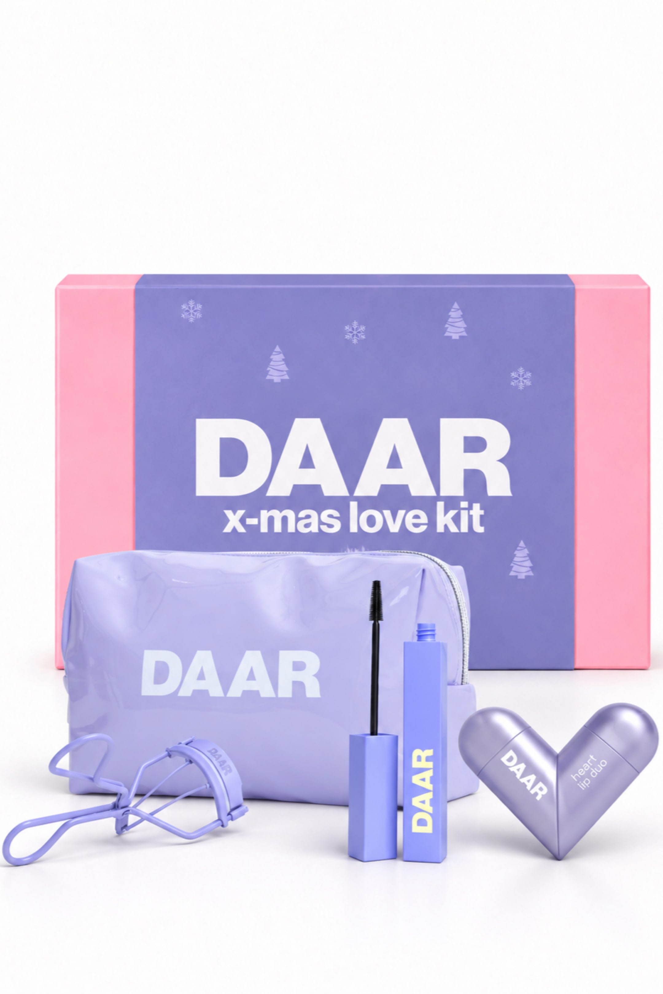 Se større billede: Et DAAR beauty-gavesæt viser en rektangulær pink og lilla æske mærket "DAAR x-mas love kit", som står bag koordinerede lyse lilla skønhedsprodukter. I forgrunden er der placeret en makeup-pung med lynlås og hvid branding, en vippebukker, en åben mascara-tube med børsten stående oprejst samt en metallisk, hjerteformet lip duo-beholder.