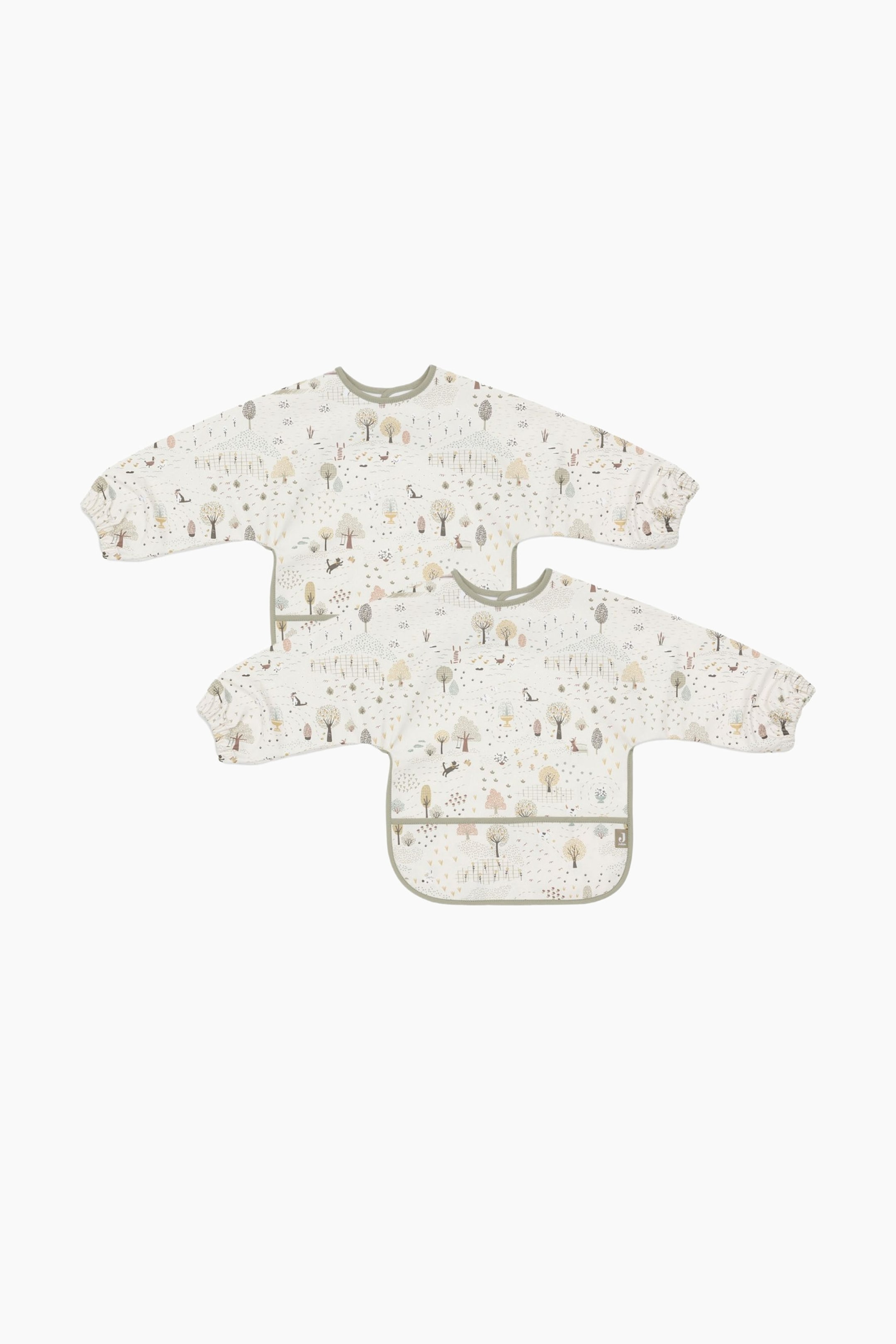 Größeres Bild anzeigen: Zwei langärmelige Baby-Lätzchen sind sichtbar, flach hingelegt, wobei eines teilweise das andere überlappt. Jedes Lätzchen zeigt einen weißen Hintergrund mit einem detaillierten Waldmuster von Bäumen, Hirschen und Kaninchen und ist mit einem runden Halsausschnitt, hellgrünem Besatz, elastischen Bündchen und einer vorderen Auffangtasche versehen.
