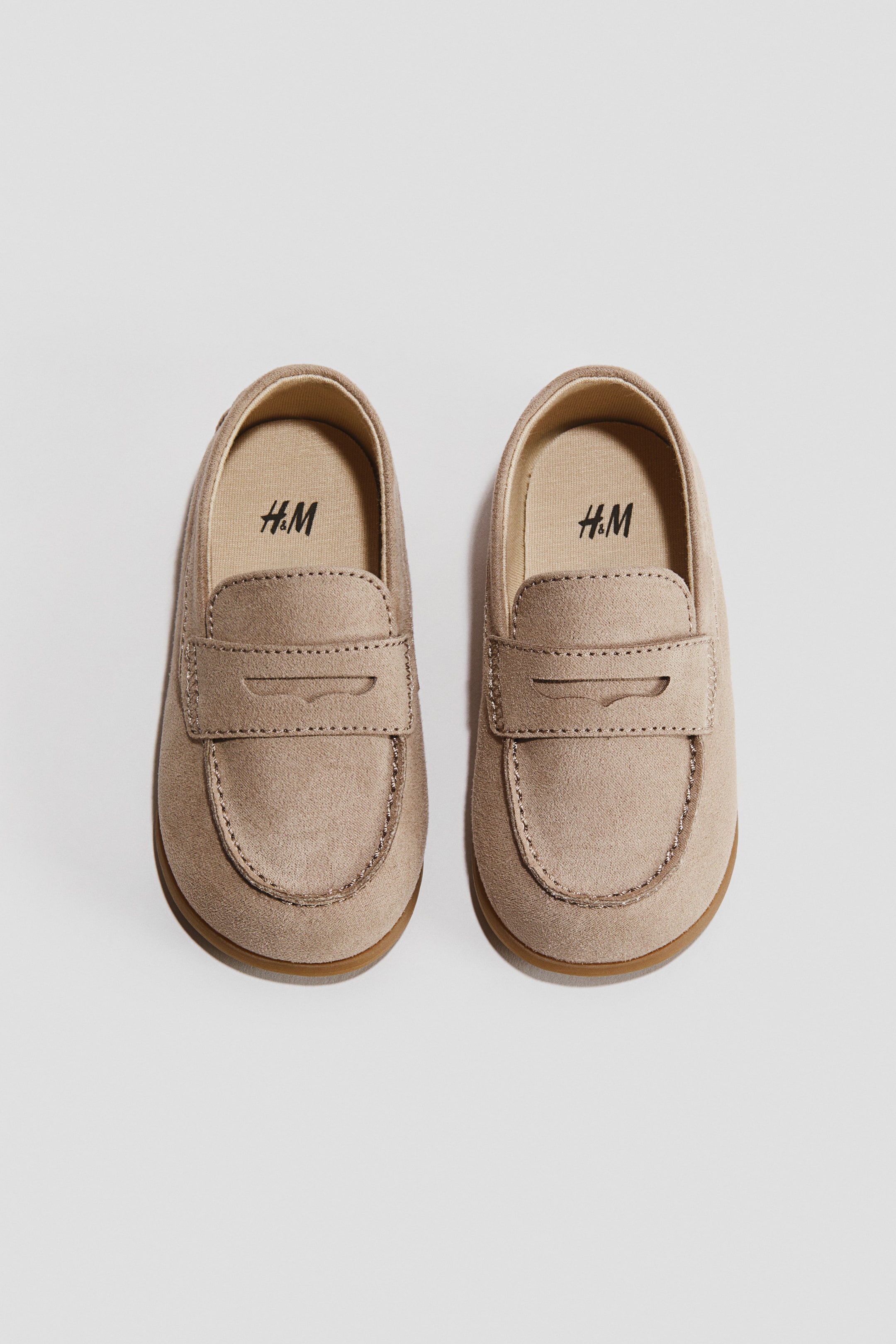 View larger image: Barefoot loafers feature a light beige, suede-like upper, detailed with a classic penny loafer strap and moccasin-style toe stitching. A light brown sole completes the design, and the H&M logo is visible on the insole.