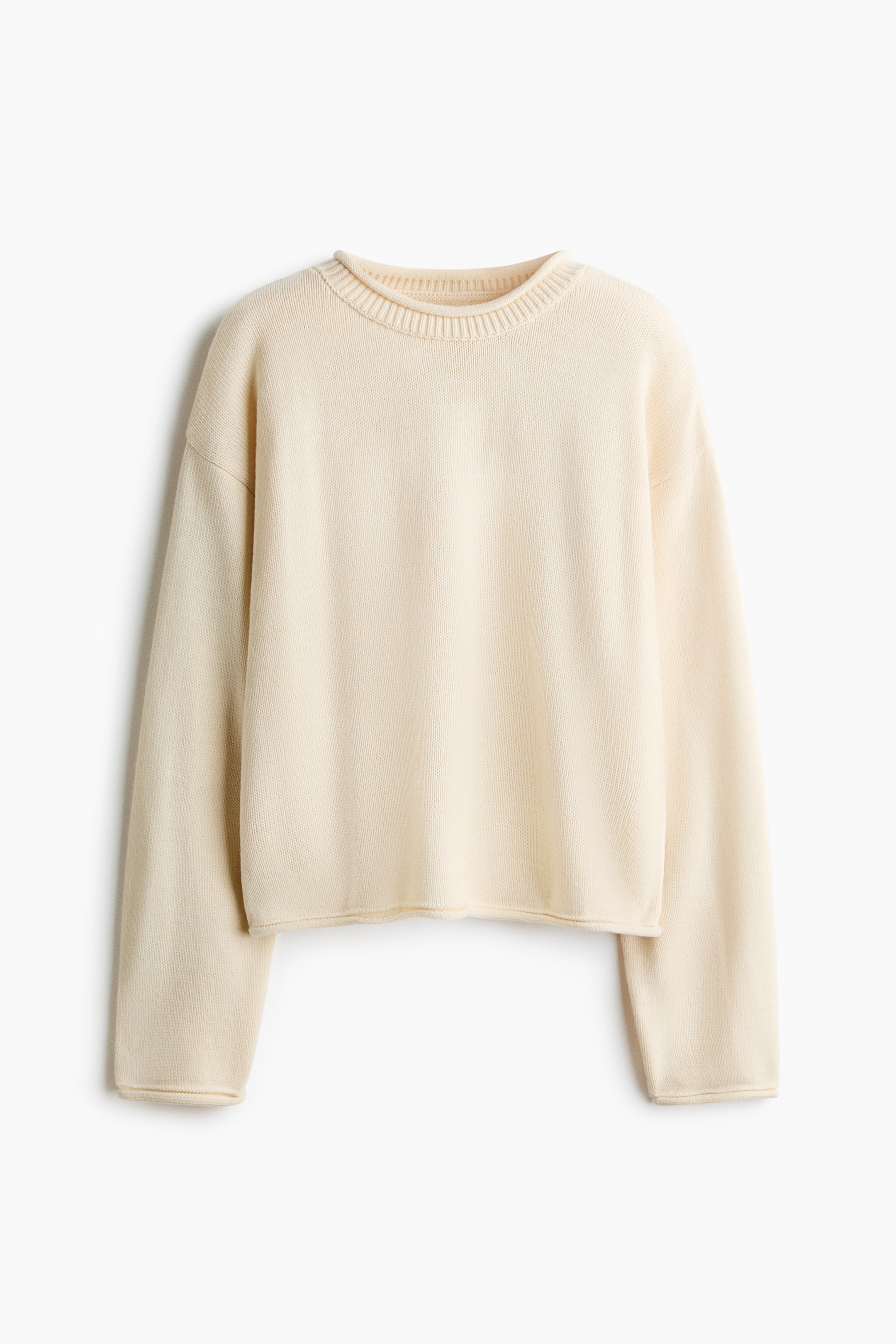 Größeres Bild ansehen: Ein cremefarbener Strickpullover hängt mit der Vorderseite nach vorne und verfügt über einen gerippten Rundhalsausschnitt, überschnittene Schultern sowie lange Ärmel mit umgeschlagenen Bündchen und einem dazu passenden umgeschlagenen Saum.