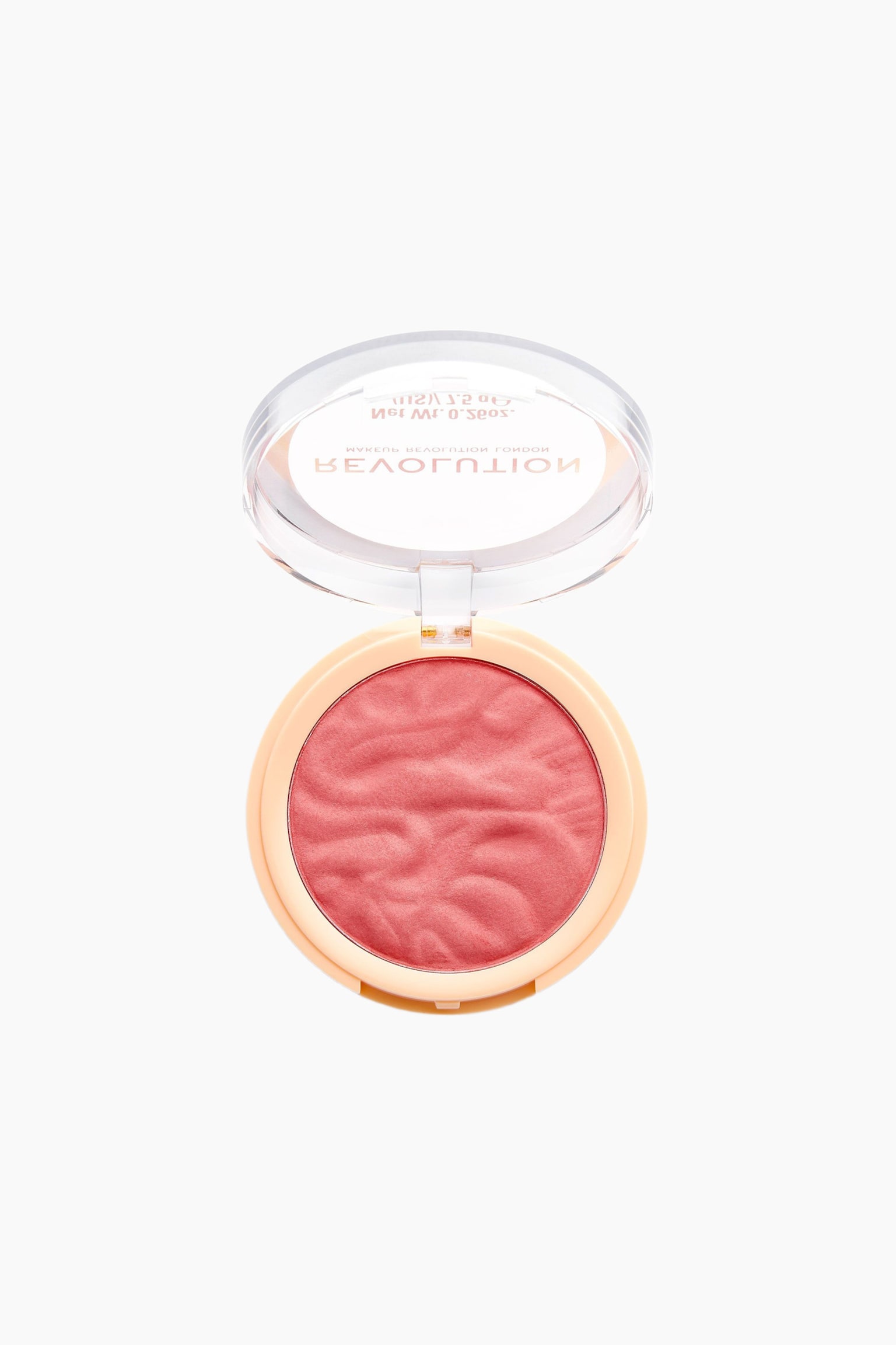 En rund blush-kompakt ligger Ã¥ben set oppefra og viser en lyserÃ¸d pudderblush med et tekstureret, bÃ¸lget mÃ¸nster i en lys ferskenfarvet beholder. Det gennemsigtige lÃ¥g er lÃ¸ftet opad og viser brandnavnet "REVOLUTION" i guldbogstaver. - 1