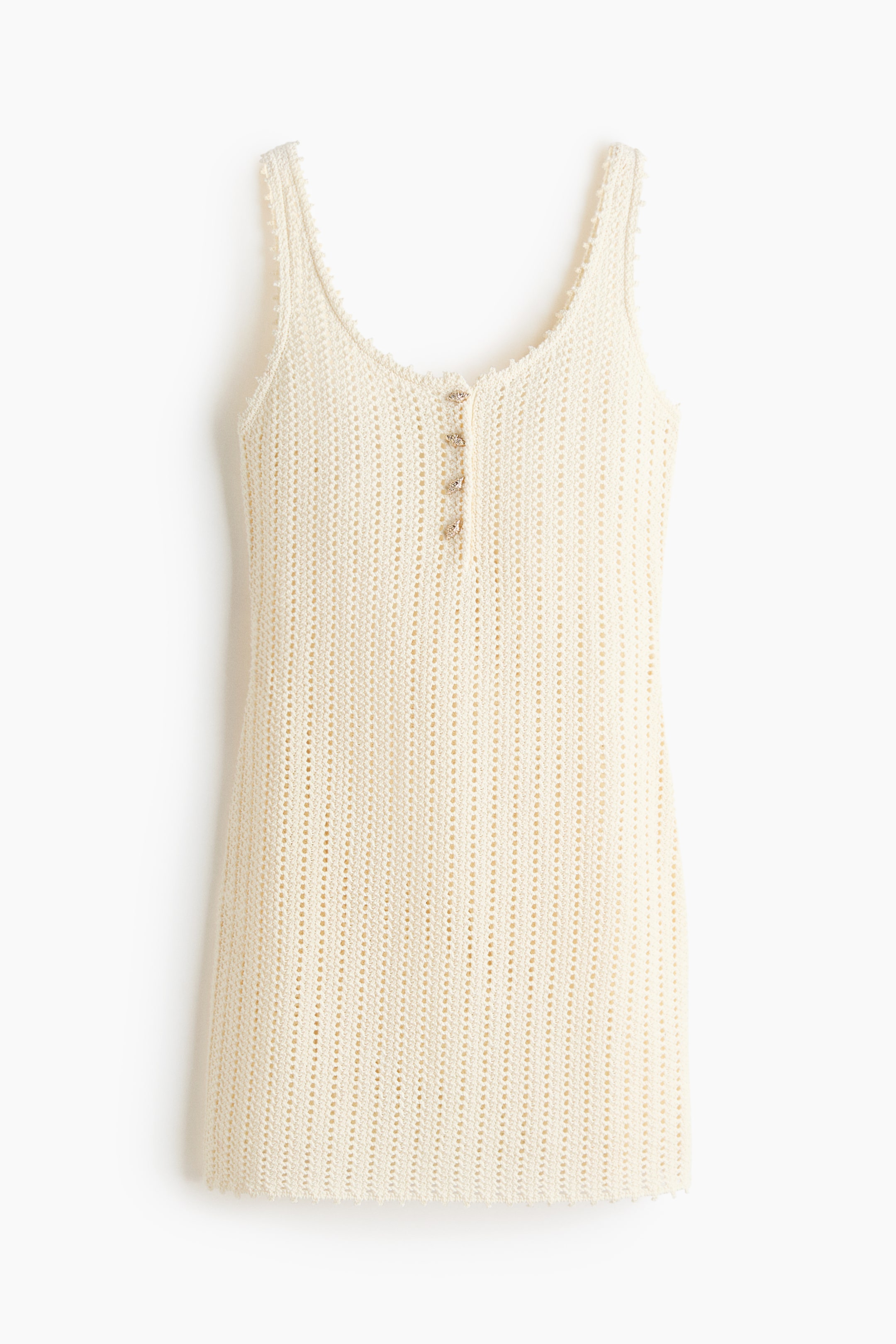 View larger image: A cream knitted tank top is showcasing a front view, featuring a vertical open-knit pattern, a scoop neckline, and wide straps. It is displaying a front placket adorned with four small decorative buttons, and its neckline, straps, and hem are finished with a textured, picot-style edge.