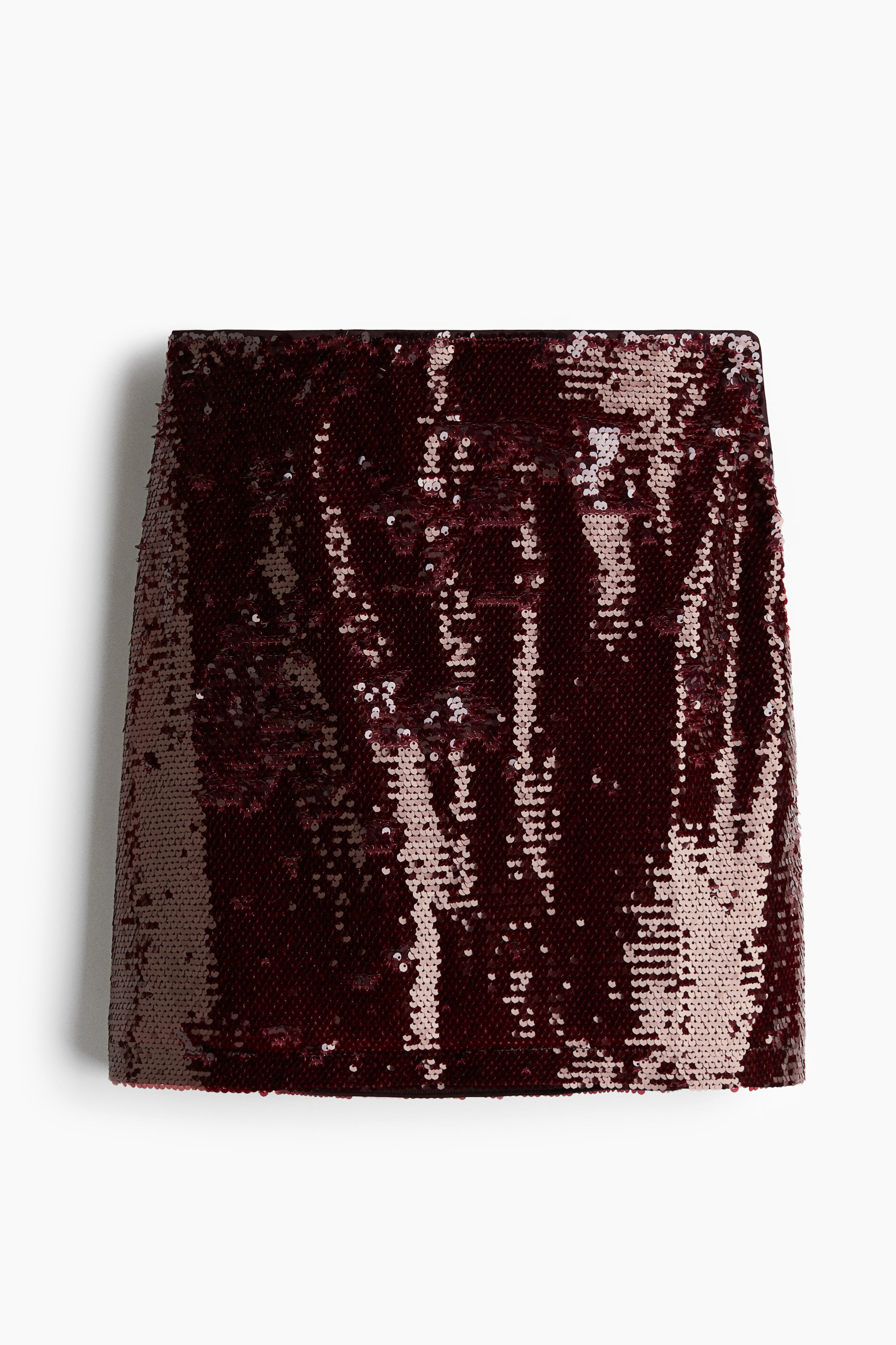 View larger image: A front-facing straight-cut mini skirt is featuring all-over reversible sequins in shades of burgundy and light pink.