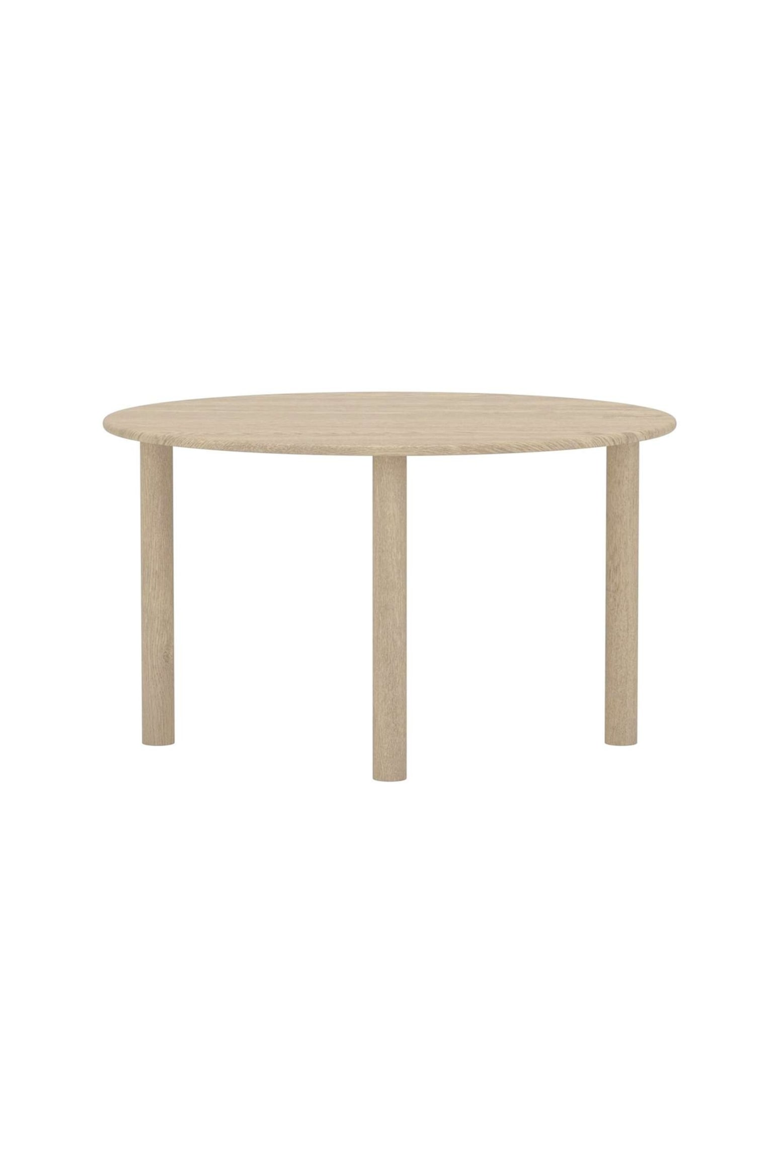 Una mesa redonda presenta un tablero de madera clara con vetas visibles. Tres patas cilíndricas, también de madera clara, la sostienen, y la pieza se muestra desde un ángulo ligeramente elevado y frontal. - 1