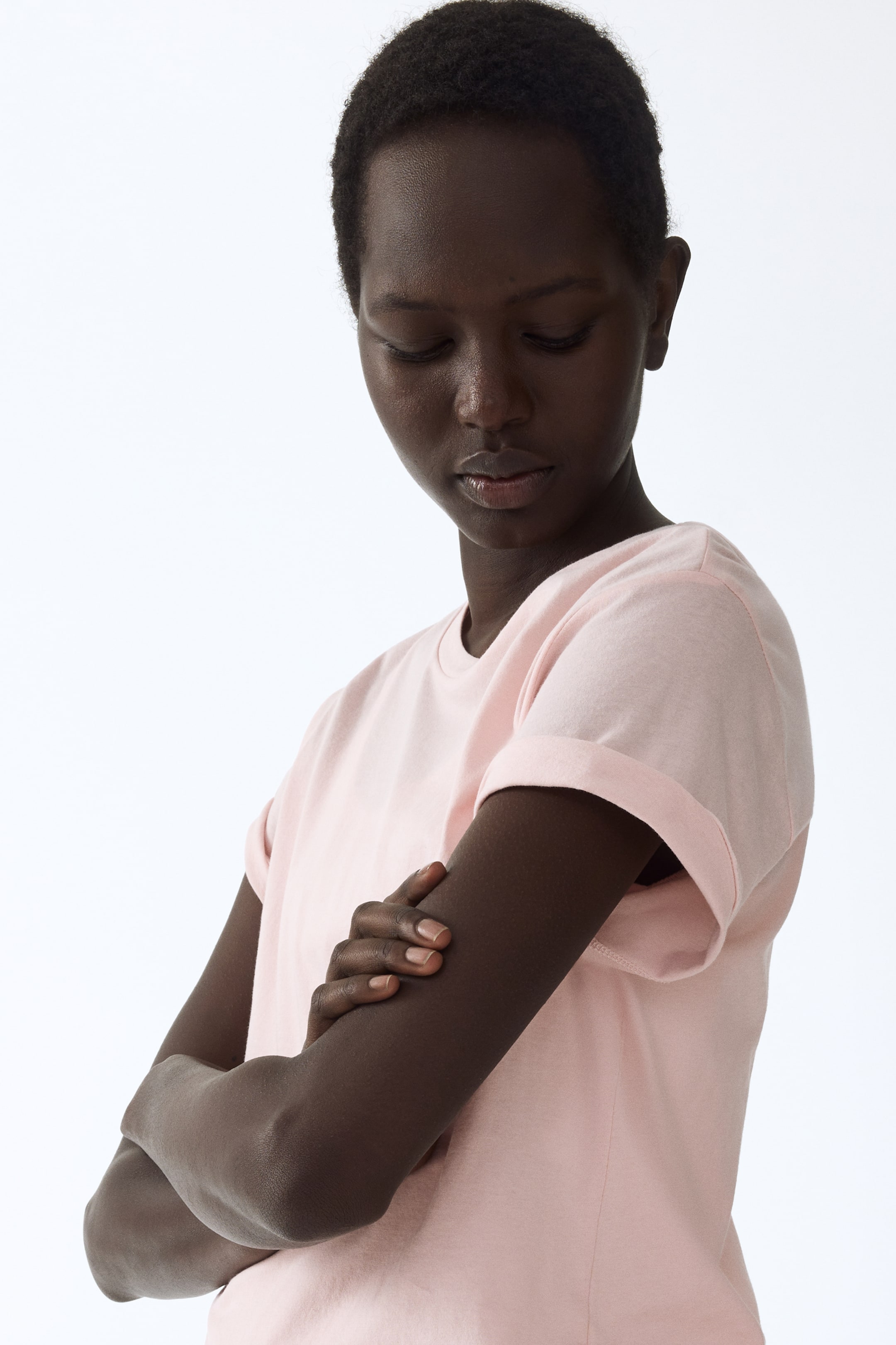 View larger image: A light pink t-shirt featuring a crew neck and cuffed short sleeves, offering a relaxed fit.