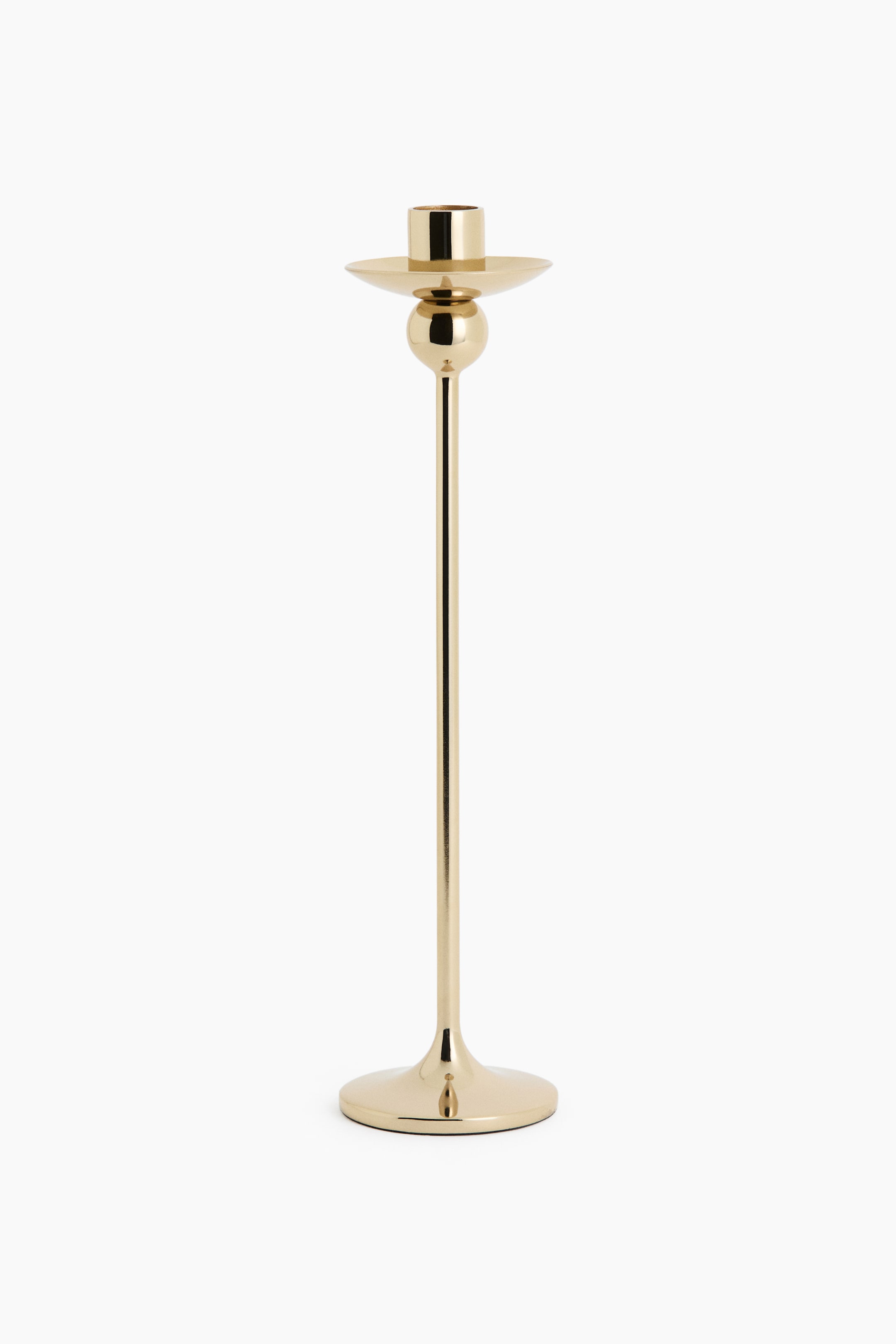 View larger image: A tall candlestick in a polished gold-tone finish is shown from the front, featuring a sleek, slender stem rising from a flared circular base. The design includes a spherical detail positioned directly below a wide, shallow drip pan and a cylindrical candle holder at the top.