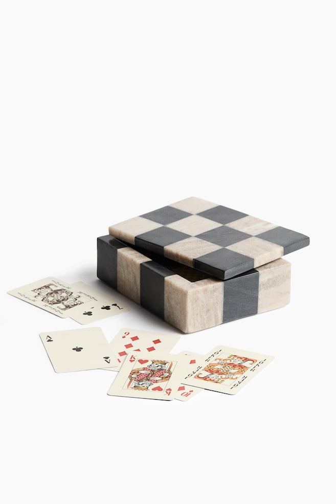 Une boîte carrée en marbre ornée dâun motif damier noir et crème est posée, son couvercle légèrement entrouvert. Plusieurs cartes à jouer sont éparpillées devant la boîte, affichant Õ¿Õ¡ÖÕ¢Õ¥Ö enseignes et figures. - 1