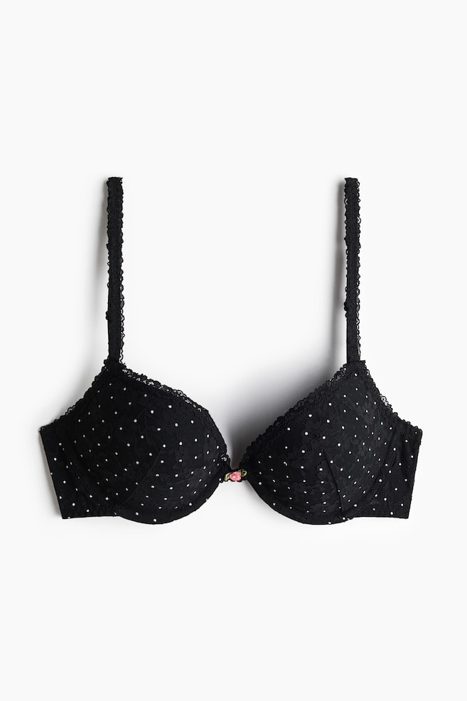 Un sutien negru push-up din dantelÄ este prezentat din faÈÄ, avÃ¢nd cupe cu sÃ¢rme Èi buretate, decorate cu un model alb cu buline Èi un mic detaliu cu boboc de trandafir roz Ã®n centru. Sutienul este realizat cu bretele reglabile, finisate cu dantelÄ. - 1