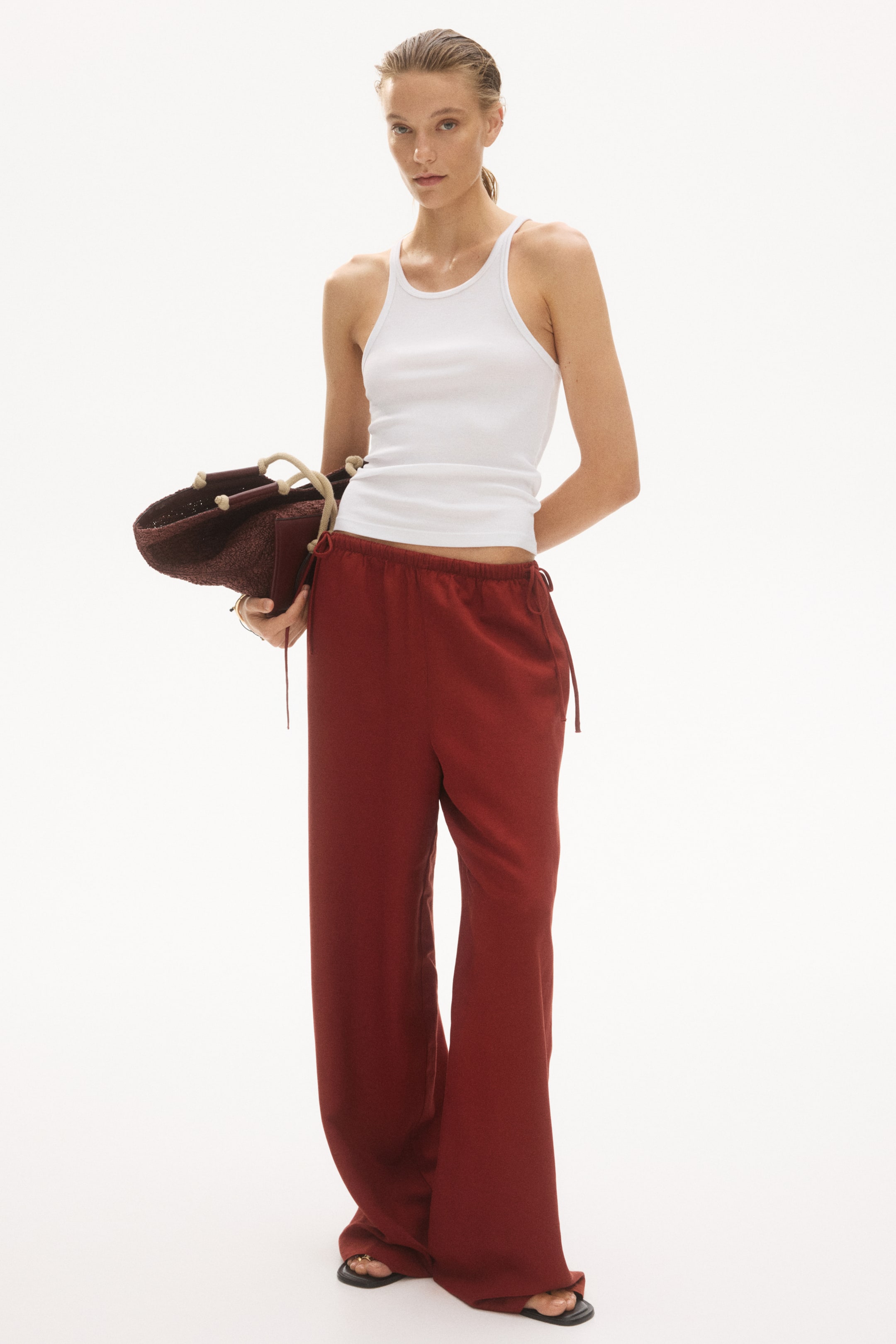 Agrandir l'image: Pantalon ample en mélange de lin aéré brun-rouge, doté d'une taille haute élastiquée avec un cordon de serrage à double extrémité, des poches latérales discrètes et des jambes larges, présenté de face.