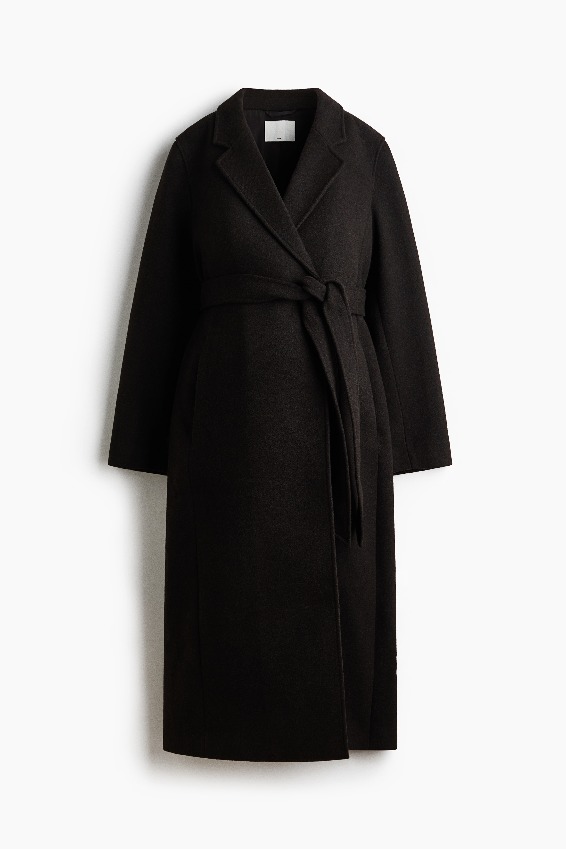 A dark olive-green, calf-length woven coat is being worn by the model, shown from the rear. The coat features a matching tie belt draped loosely across the back waist and a single back vent at the bottom hem.