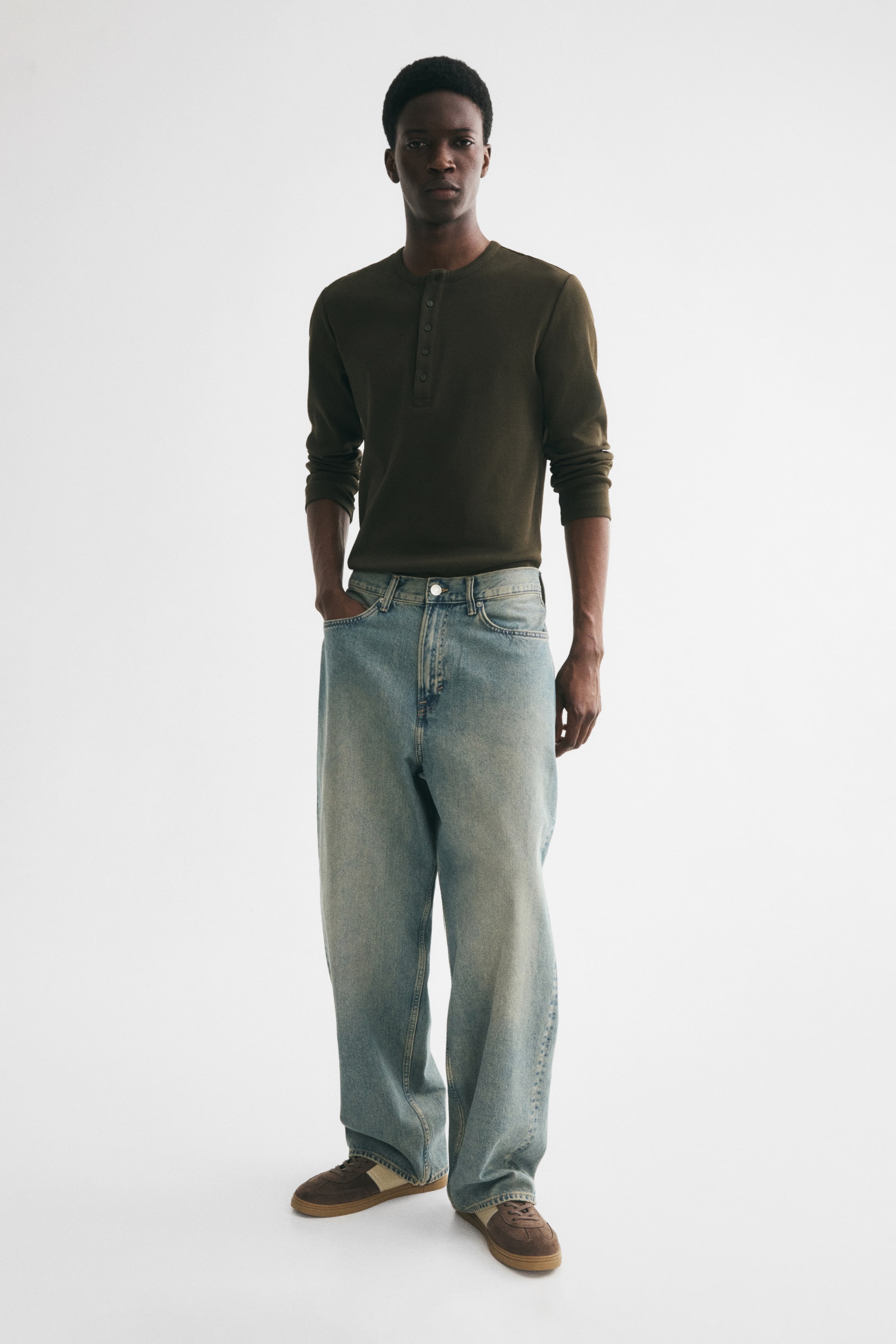 Grösseres Bild ansehen: Hellblaue 5-Pocket-Jeans aus festem Baumwoll-Denim werden vom Model getragen. Sie zeichnen sich durch eine normale Taille, einen Reißverschluss, einen tiefen Schritt und eine lockere, abgerundete Beinpassform aus, die sich am Knöchel staut.