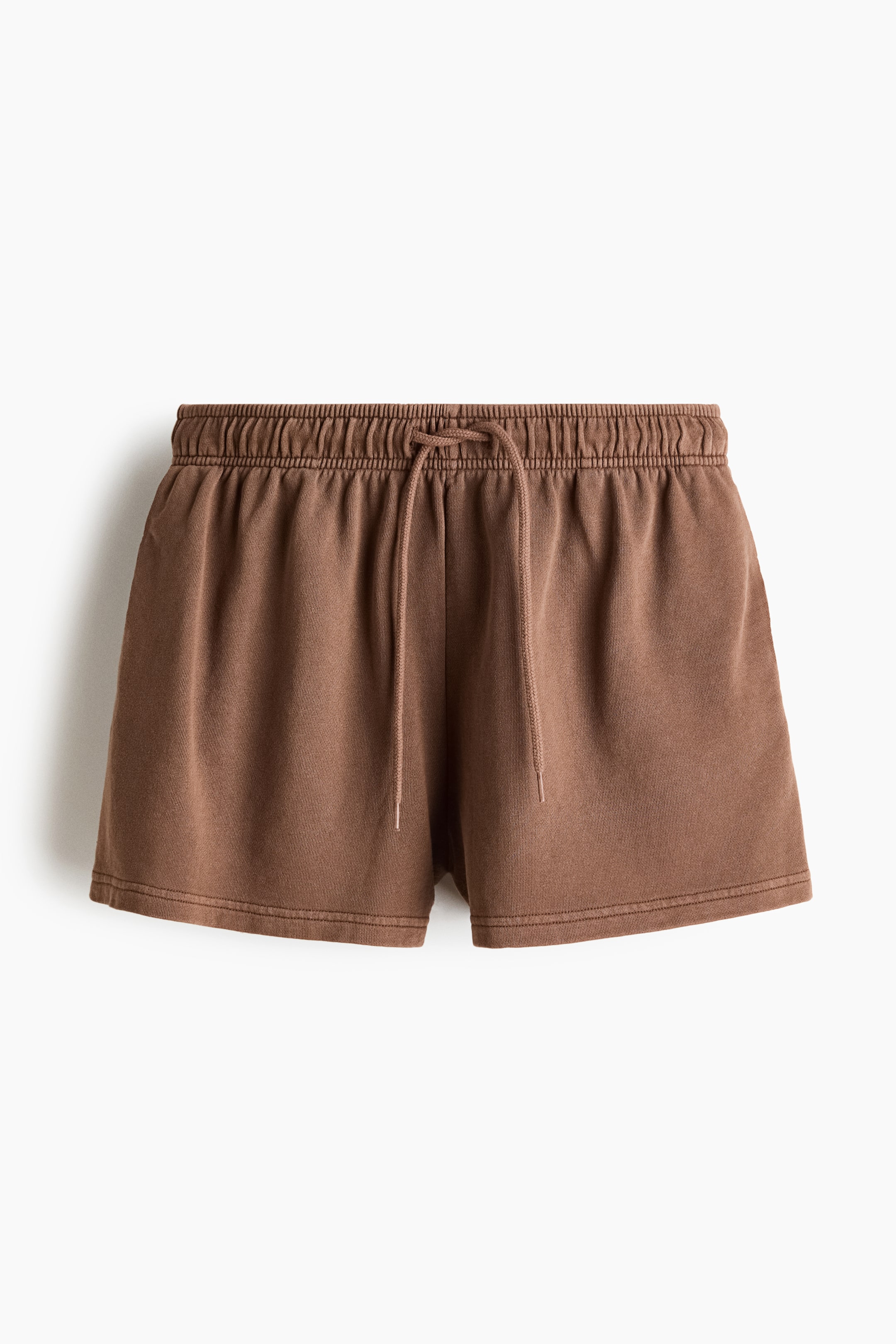 View larger image: Washed brown shorts feature an elastic, ruched waistband with a front-tied drawstring. They offer a relaxed fit and short legs, with visible stitching at the hems.