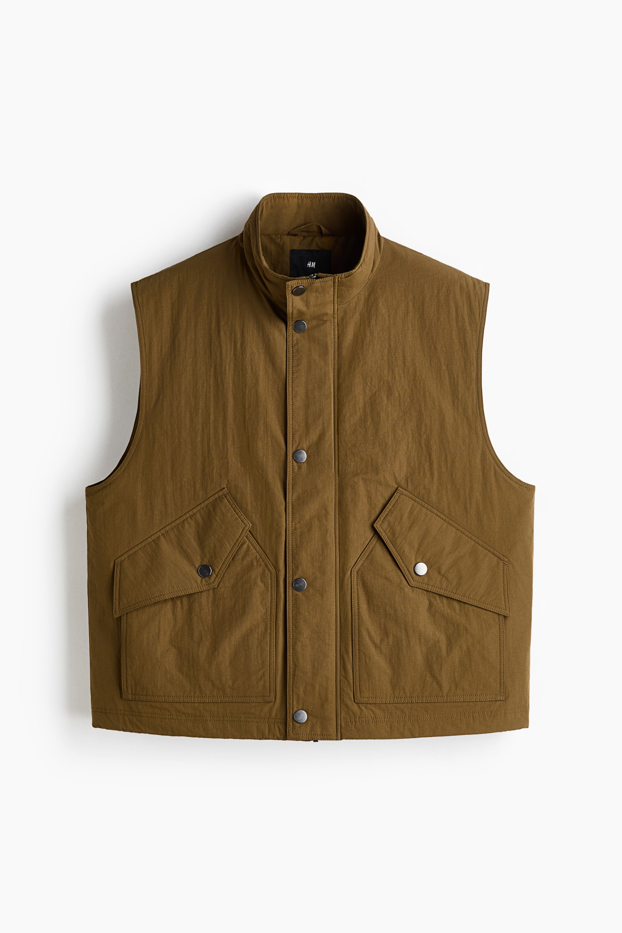 View larger image: A muted olive green vest showcases its front, featuring a stand-up collar and a full snap-button placket. Two large flap pockets with snap closures are visible on the lower front.