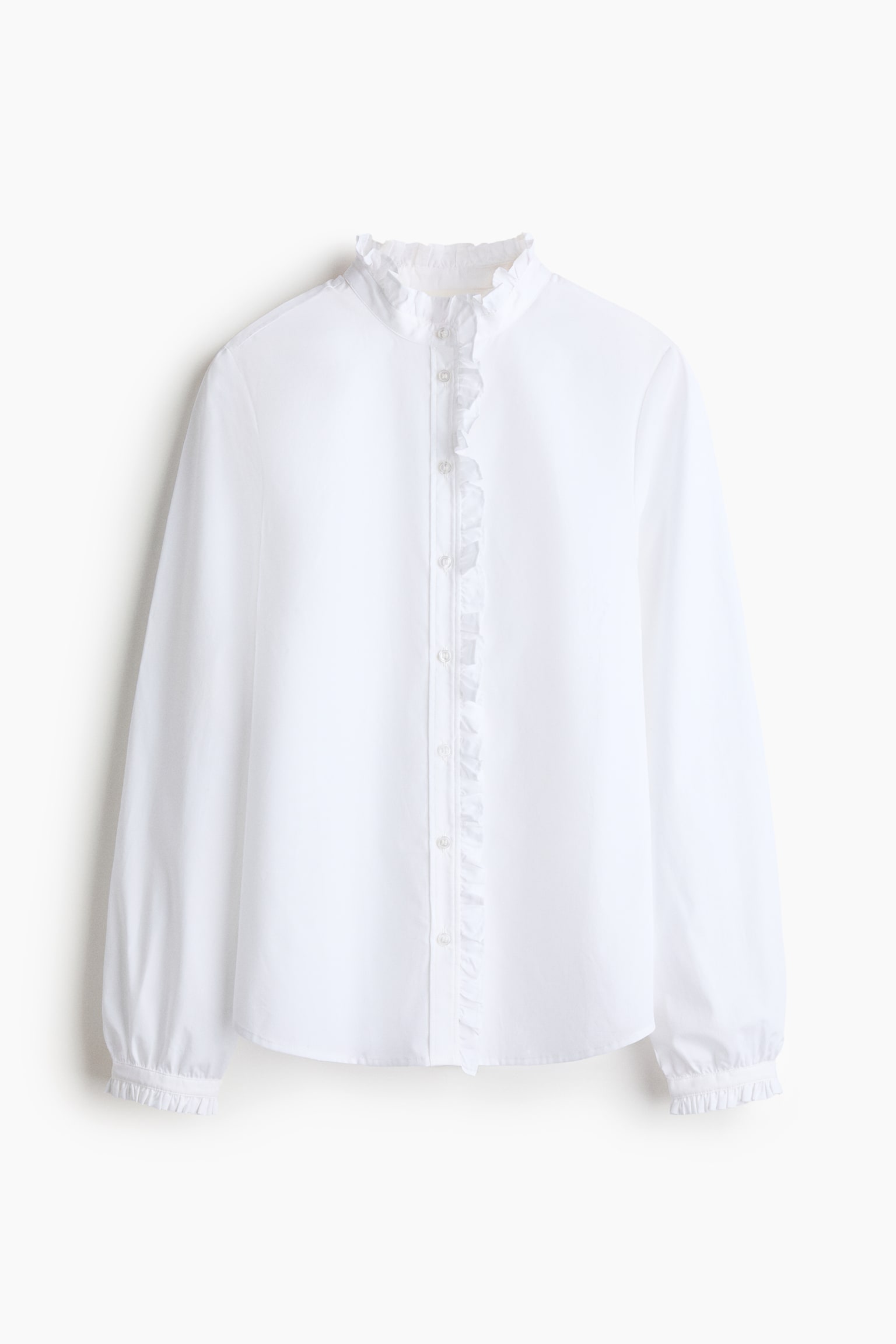 A white blouse is shown from the front, featuring a ruffled stand-up collar and a full-button placket with vertical ruffles. Its long sleeves end with ruffled elasticated cuffs.