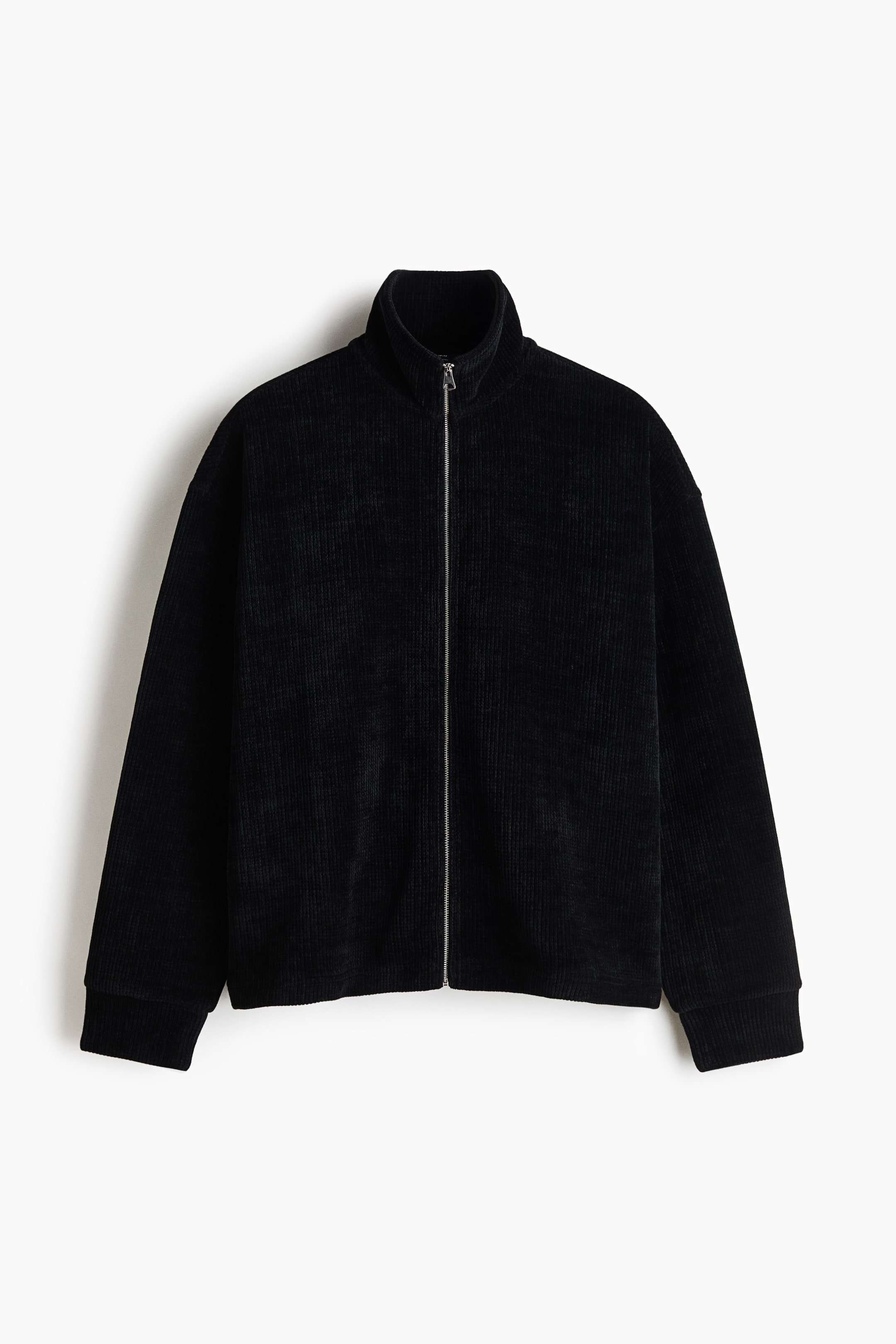 View larger image: A black ribbed jacket with a corduroy-like texture is shown from the front, featuring a full-length silver zipper, a high stand-up collar, and long sleeves with ribbed cuffs.
