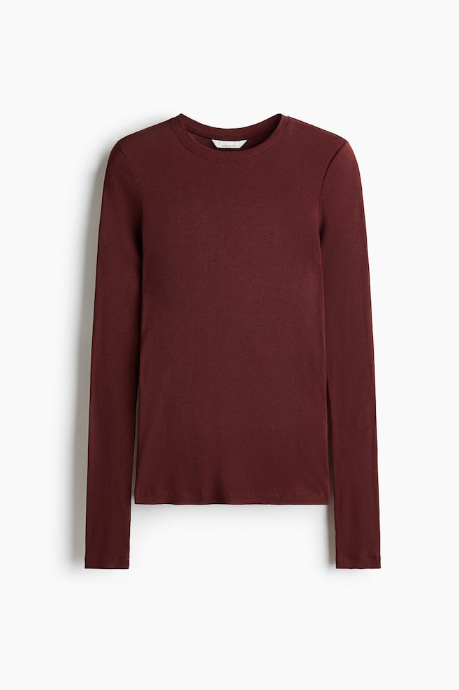 A burgundy, long-sleeved fitted top is facing forward, displaying a fine ribbed texture and a round, rib-trimmed neckline. The garment features extra-long sleeves and a straight hemline. - 1
