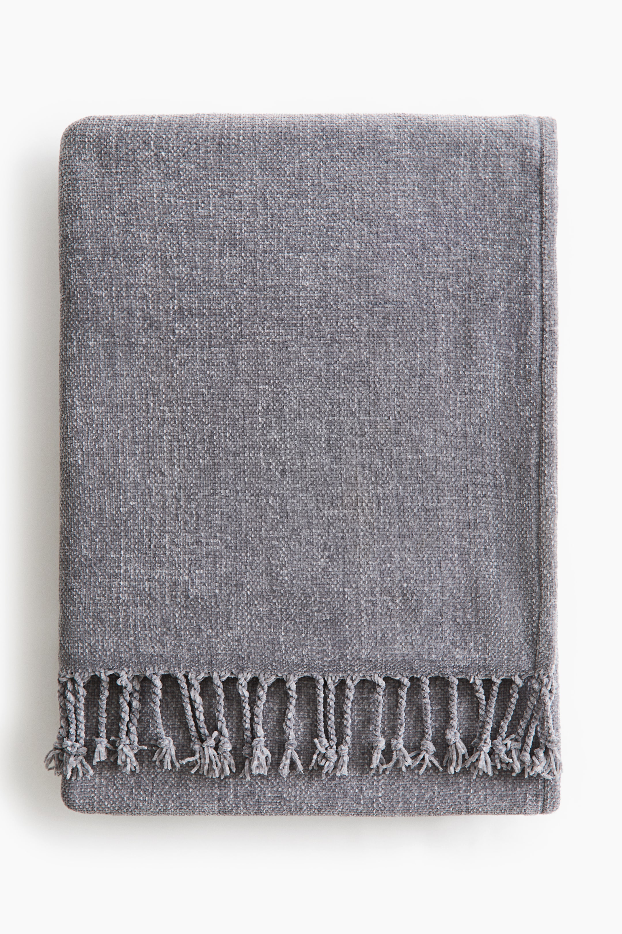 View larger image: Presenting a heathered grey throw blanket, neatly folded into a rectangle. It showcases a woven texture and is adorned with a decorative fringe along one end.