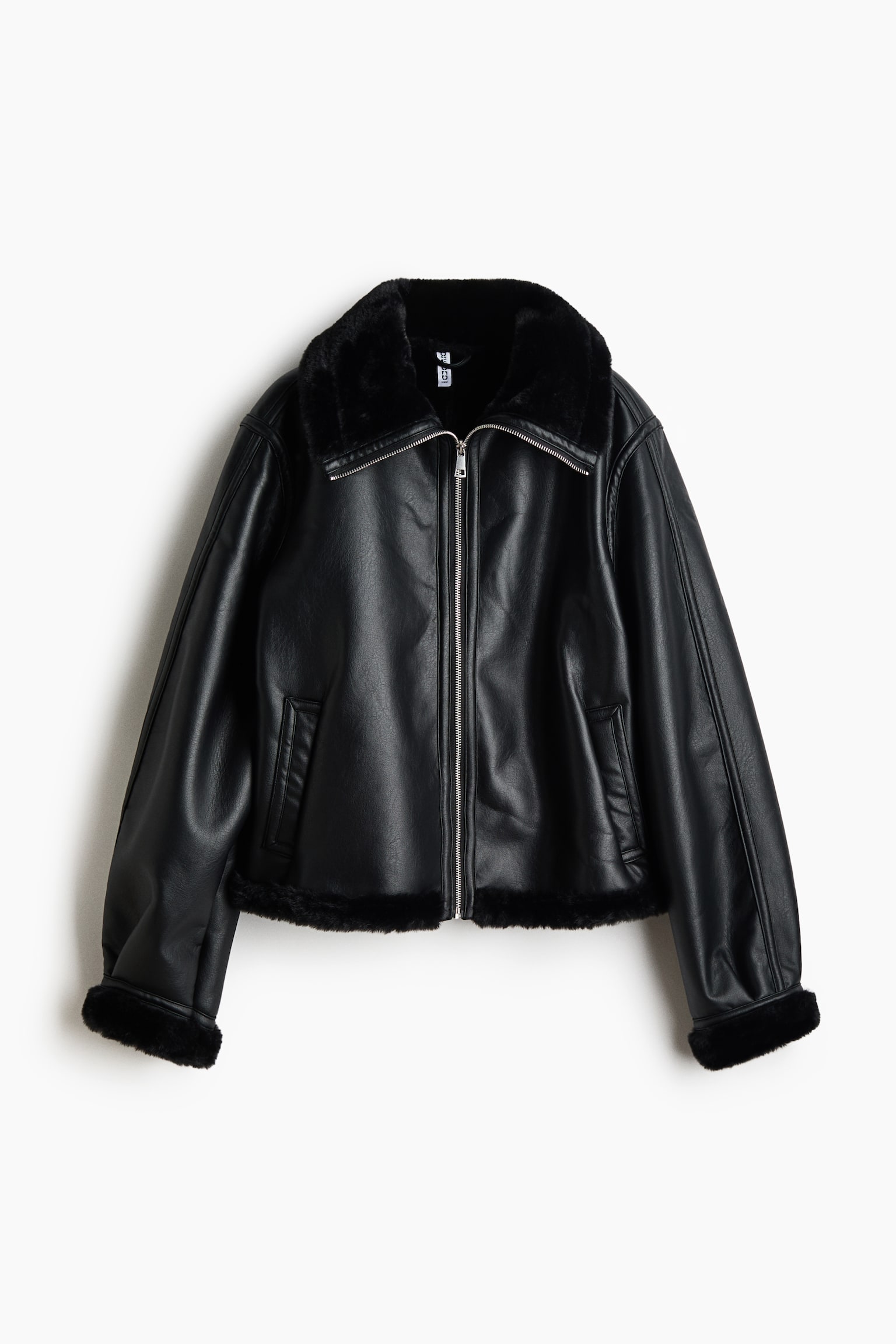A black jacket in a coated woven fabric is shown from the front, featuring a plush faux-fur funnel collar, a silver-tone front zip fastening, and welt front pockets. The design features dropped shoulders with foldover cuffs and a foldover hem, both trimmed with matching black fluffy fabric. - 1