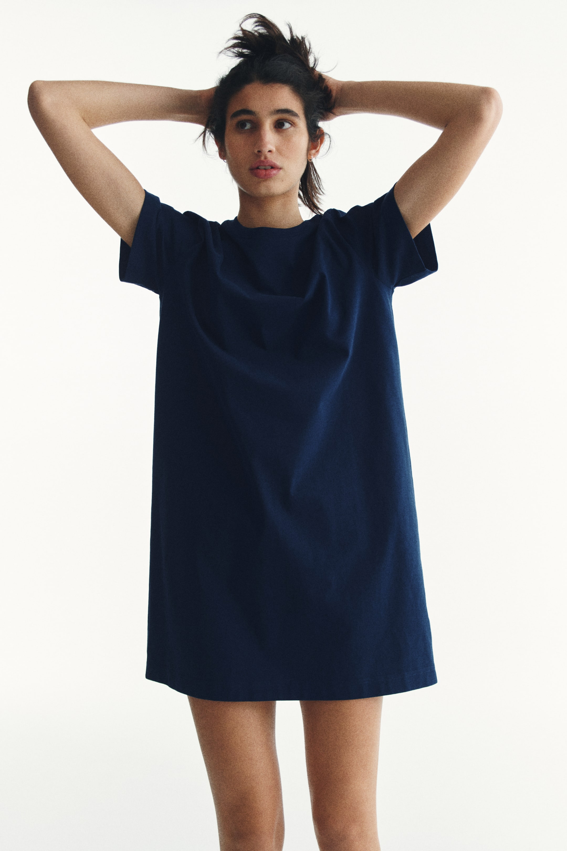 View larger image: A navy blue t-shirt dress showcasing a crew neck and short sleeves. It highlights a relaxed fit with a straight hem, ending just above the knee.