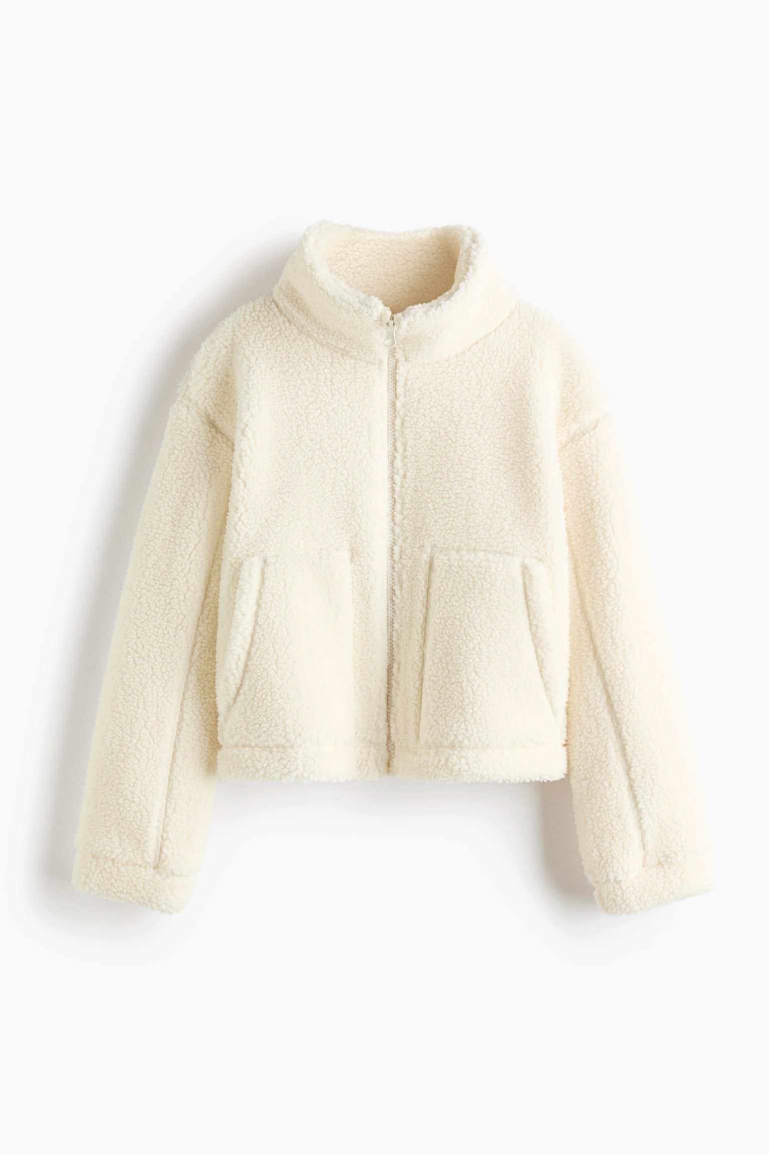 A cream teddy fleece jacket is facing forward, featuring a high stand collar and a full-length zip fastening. It showcases two large front patch pockets and long sleeves, and is cropped at the waist. - 1