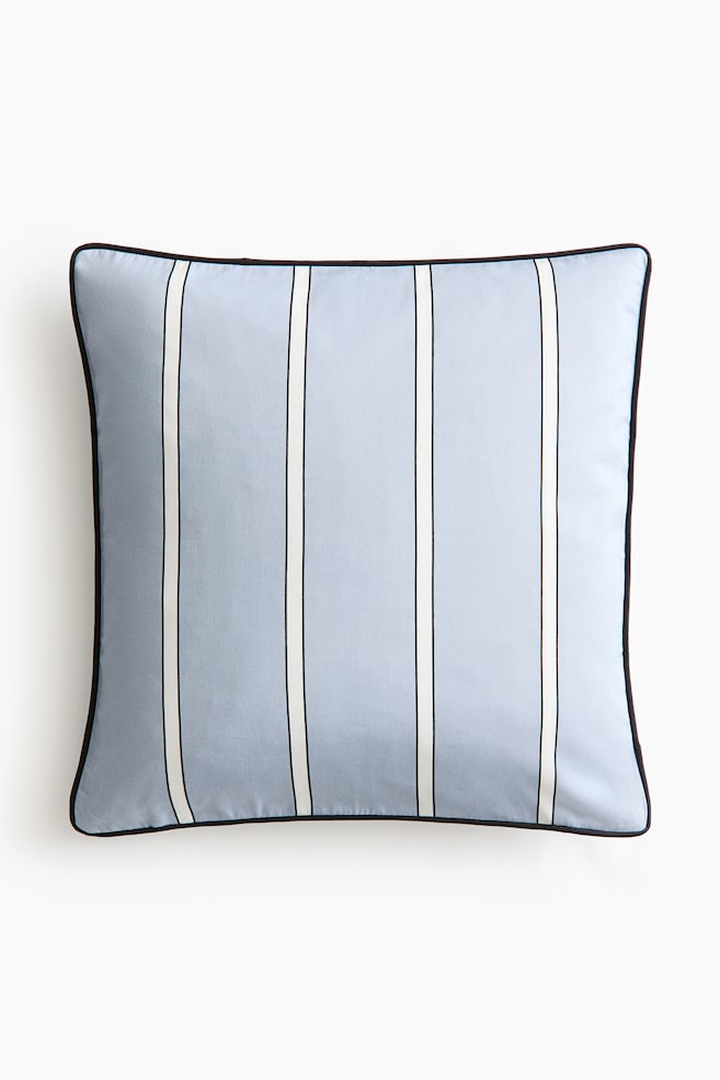 A square cushion is front-facing, featuring a light blue background with vertical stripes, each consisting of a wide white band flanked by thin black lines. Dark piping runs along its edges. - 1