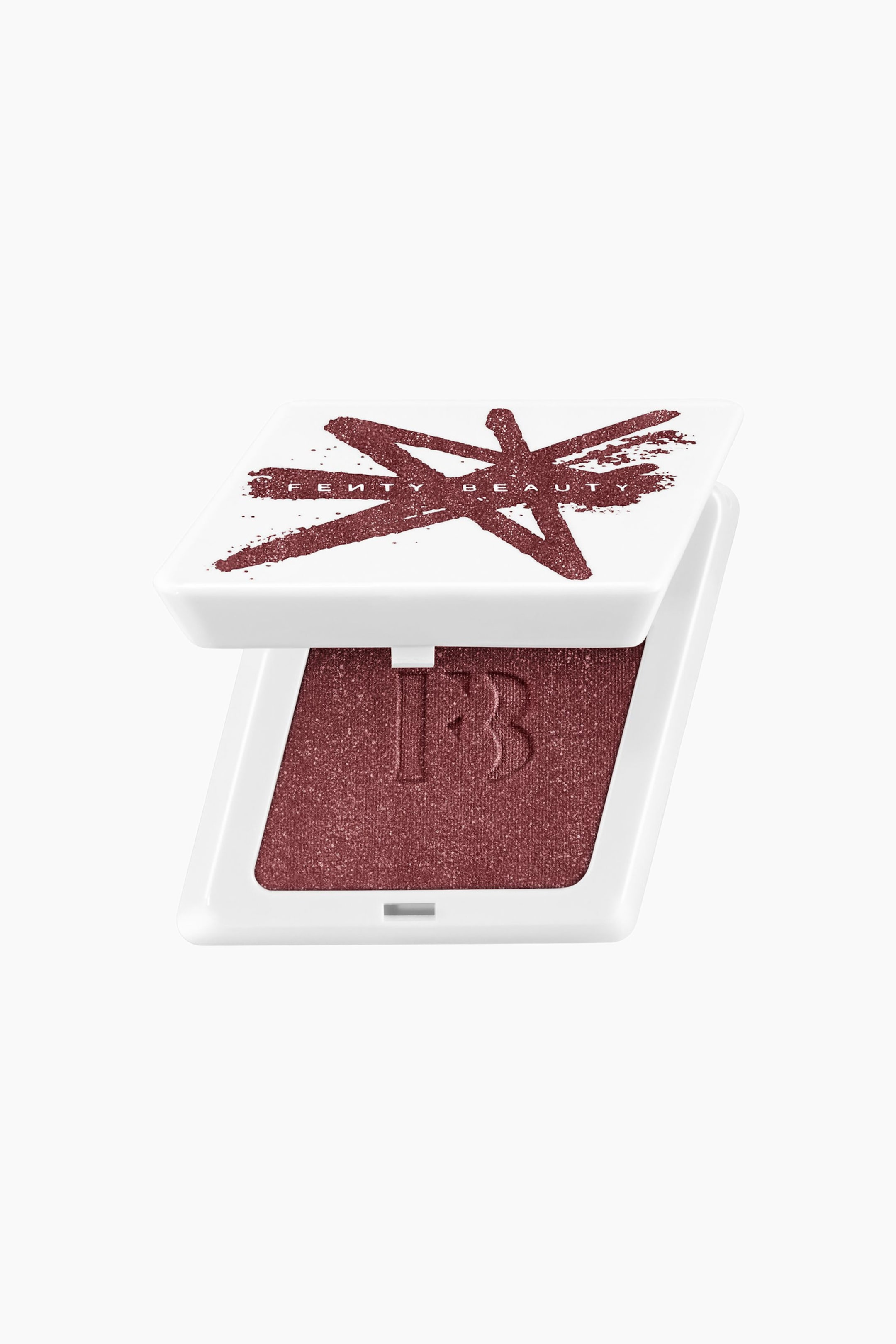 Se større billede: En firkantet, hvid pudderblush-compact står delvist åben i en trekvartsvinkel og afslører en skinnende, dyb bær-rød pudderblush præget med et "FB"-logo i midten. Det delvist løftede låg fremviser et matchende mørkerødt stjernedesign med malingstænk og "FENTY BEAUTY" trykt hen over midten.