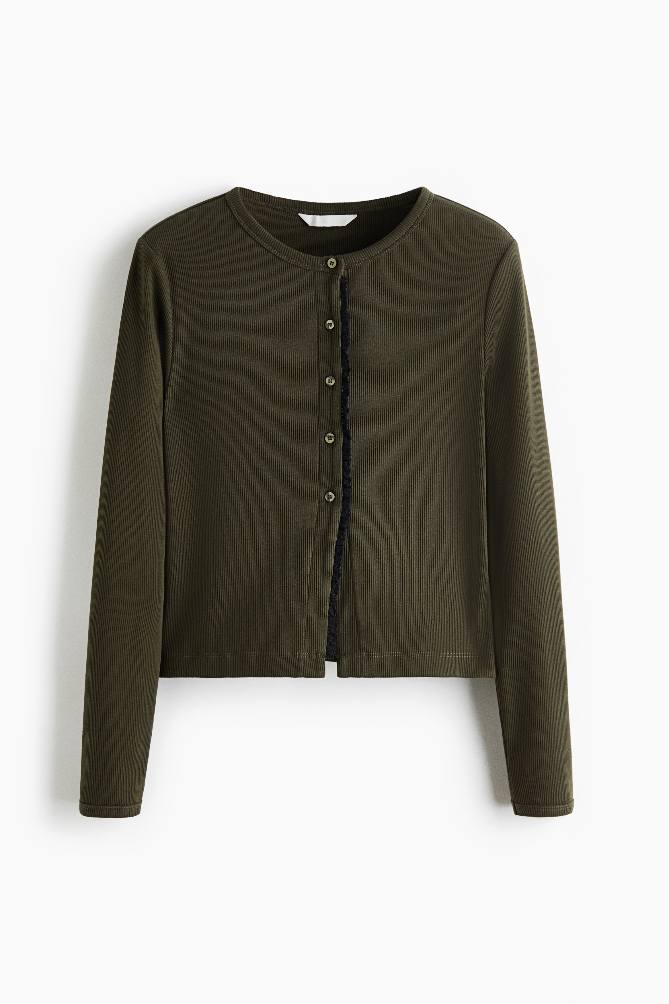 The model is wearing an olive green ribbed cardigan with a round neckline, long sleeves, and lace-trimmed edging along the partially buttoned front. It is layered over a white T-shirt and paired with light beige pants.