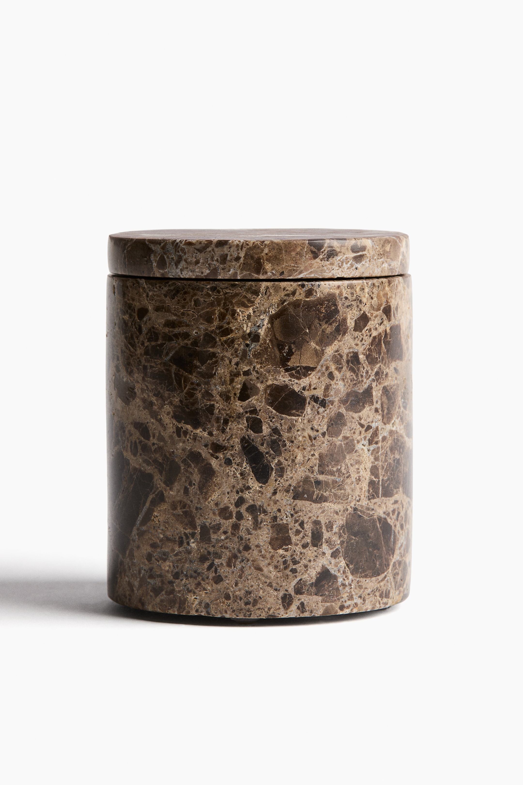 View larger image: A cylindrical mottled brown and black marble container stands upright, slightly angled forward, with its flat circular lid resting flush on the container body, showcasing the intricate marble pattern.