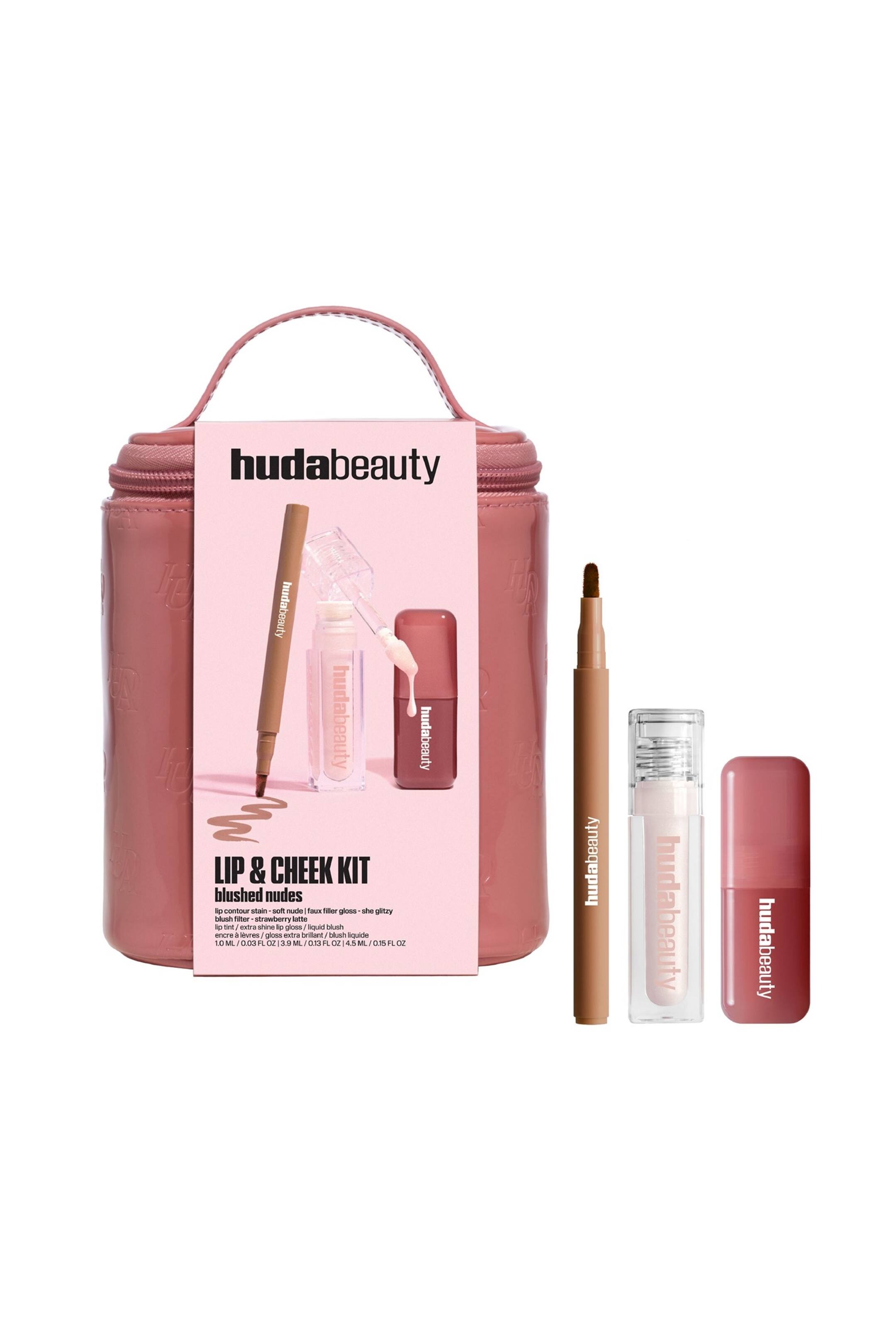 Näytä suurempi kuva: Lip & Cheek Kit Blushed Nudes -setti on pystyssä, ja siinä on pölyisen roosa vetoketjullinen meikkipussi, jossa on yläkahva, sekä vaaleanpunainen paperiholkki. Pussin vieressä on kolme kosmetiikkatuotetta: ohut ruskea huultenrajauskynä, kirkas tuubi, jossa on vaaleanpunaista huulikiiltoa, sekä pieni pölyisen roosa nestemäisen poskipunan pullo.