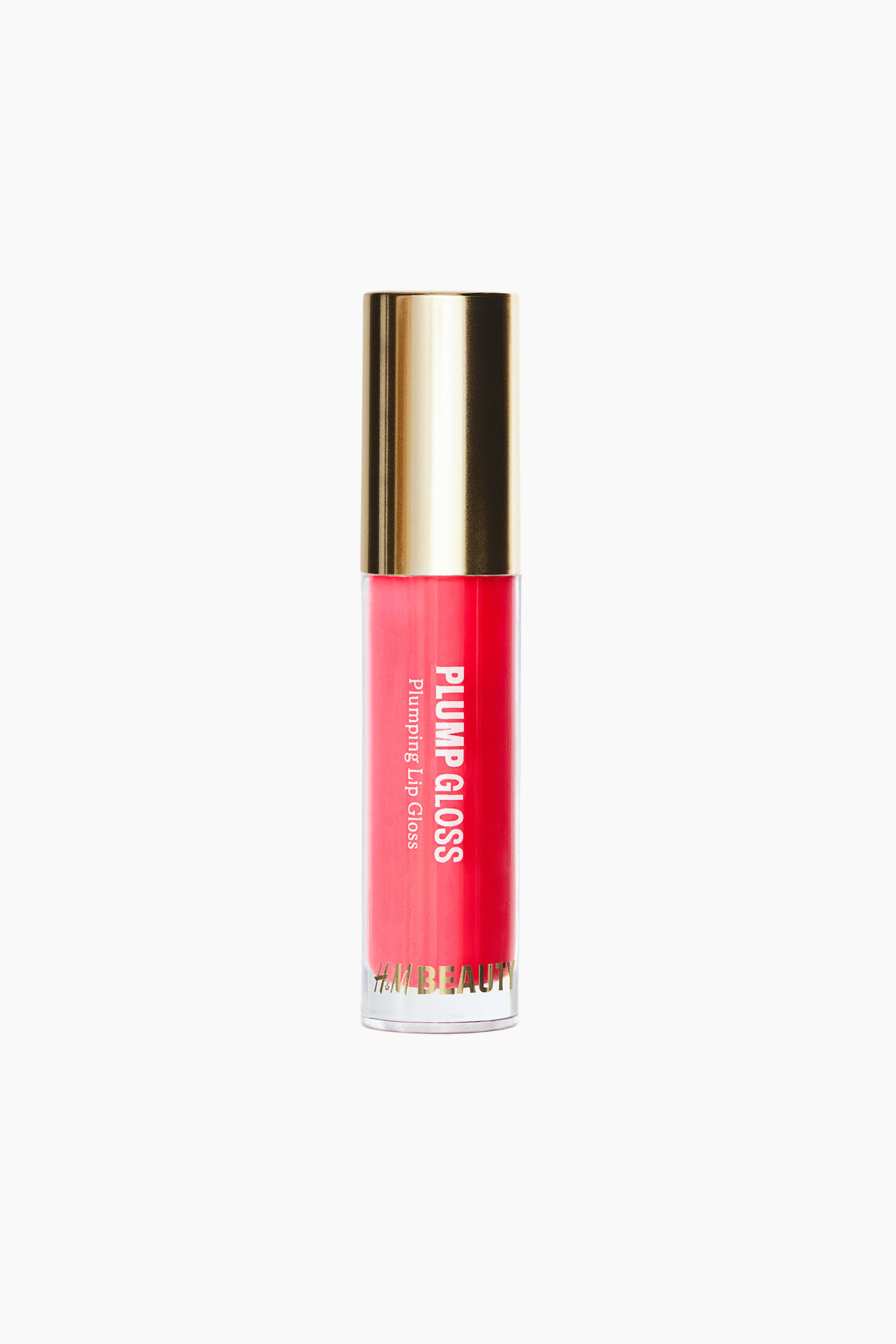 View larger image: A tube of plumping lip gloss is standing upright, facing front, showcasing a clear cylindrical container filled with vibrant pink gloss and topped with a reflective metallic gold cap. The front of the container displays vertical white text reading "PLUMP GLOSS" and "Plumping Lip Gloss," with "H&M BEAUTY" appearing in gold lettering near the base.
