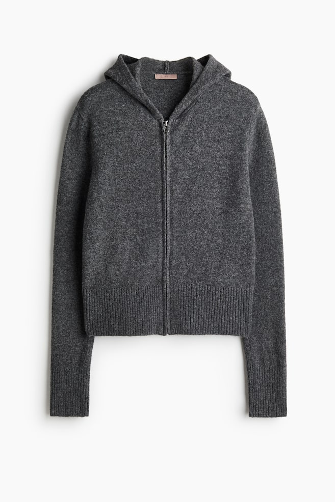 En mörkgrå stickad hoodie med dragkedja visas framifrån och har huva, en central dragkedja och långa ärmar. Plagget i kort modell har breda ribbade muddar och en matchande ribbad nederkant. - 1
