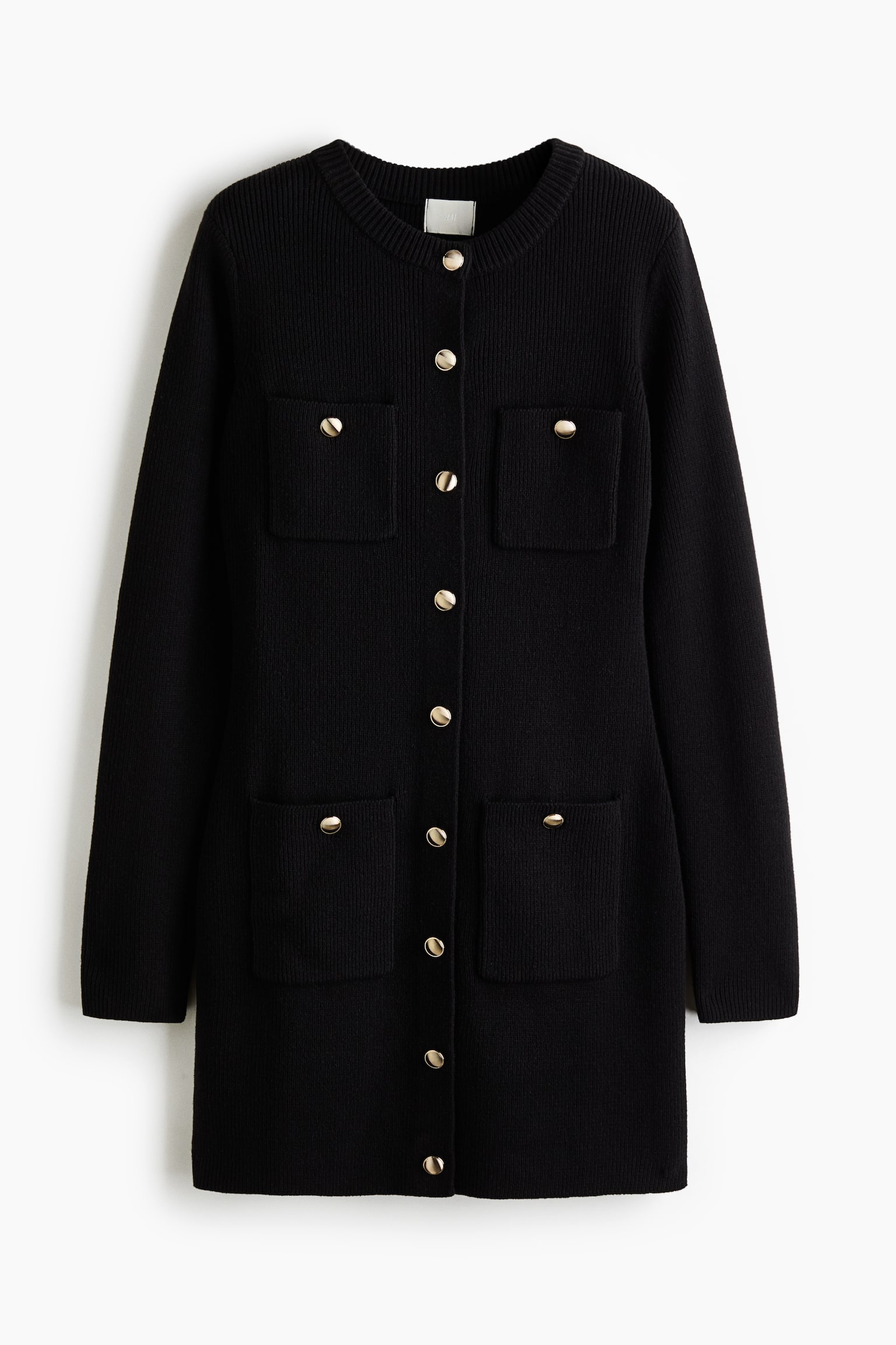 A black, long-sleeved knitted cardigan dress is shown from the front, featuring a round, ribbed neckline and a central row of gold-tone dome buttons. The dress is designed with four front patch pockets, two on the chest and two at the lower front, each accented with a matching gold-tone button.