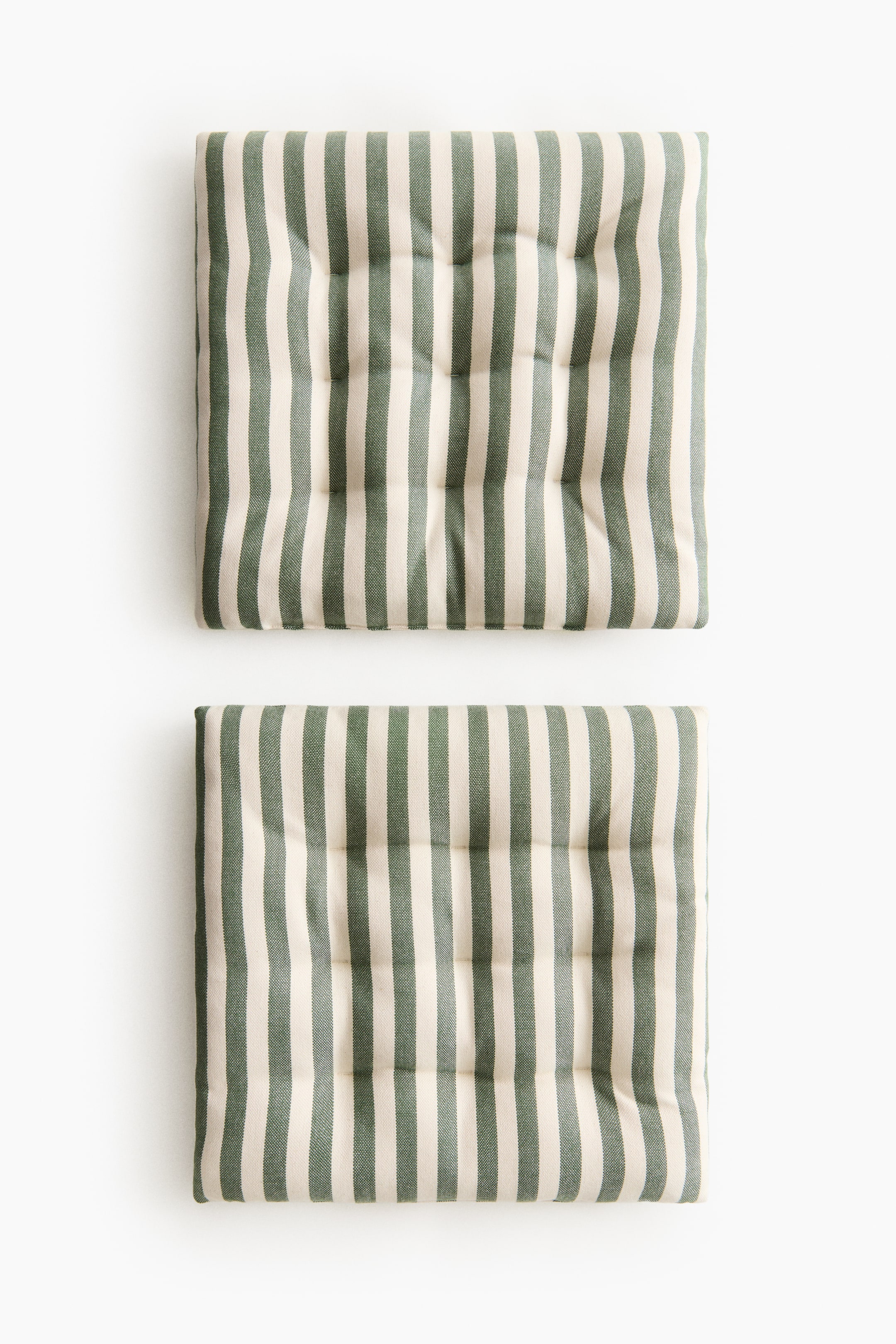 View larger image: Two square padded seat cushions are visible from the front, featuring vertical stripes in alternating cream and green colours. Quilt knots create a tufted effect across their surfaces.
