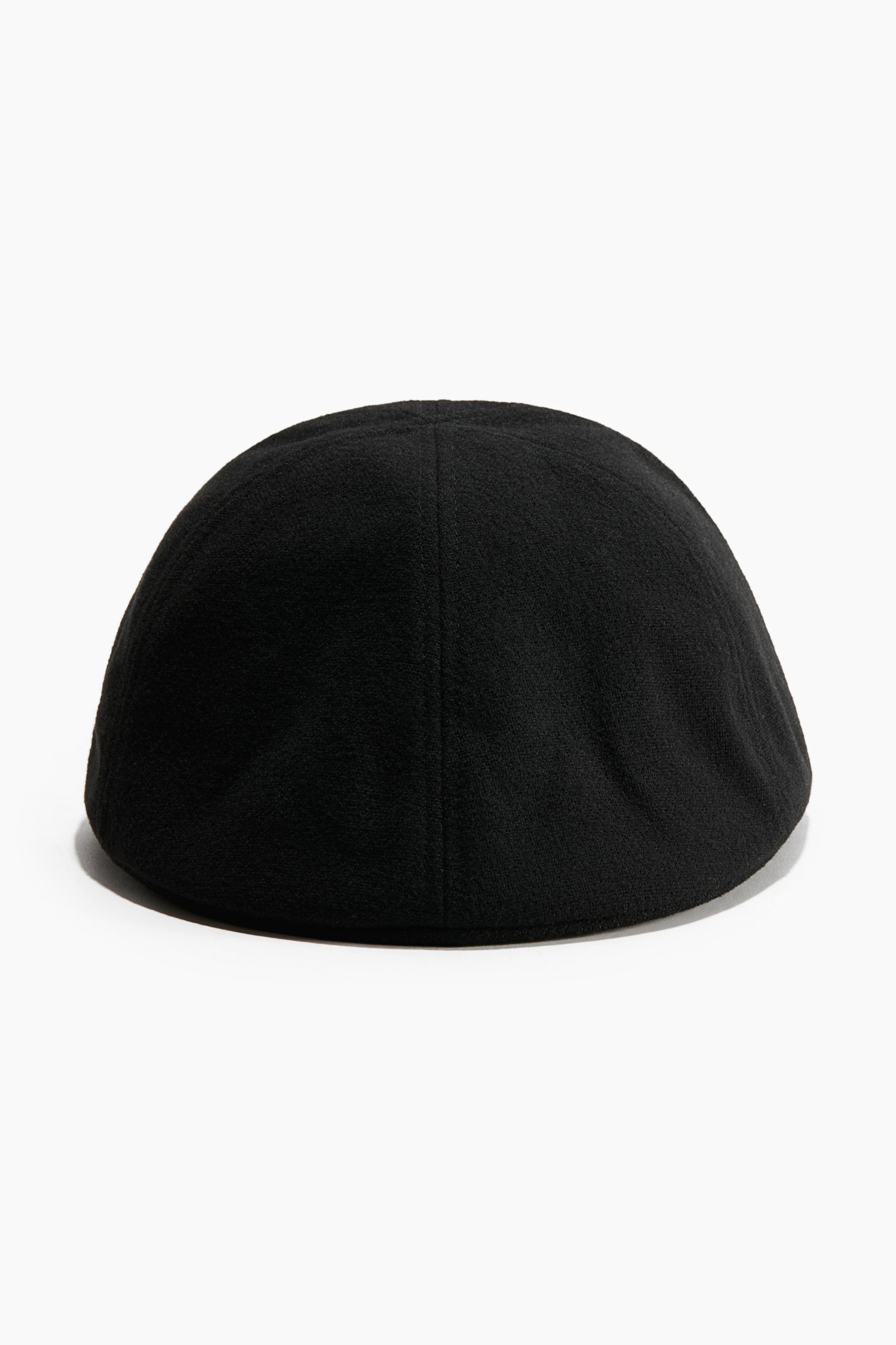 View larger image: A black flat cap crafted from a soft wool-blend fabric is facing away, showing its rounded crown shape and a clean central vertical seam from the rear.