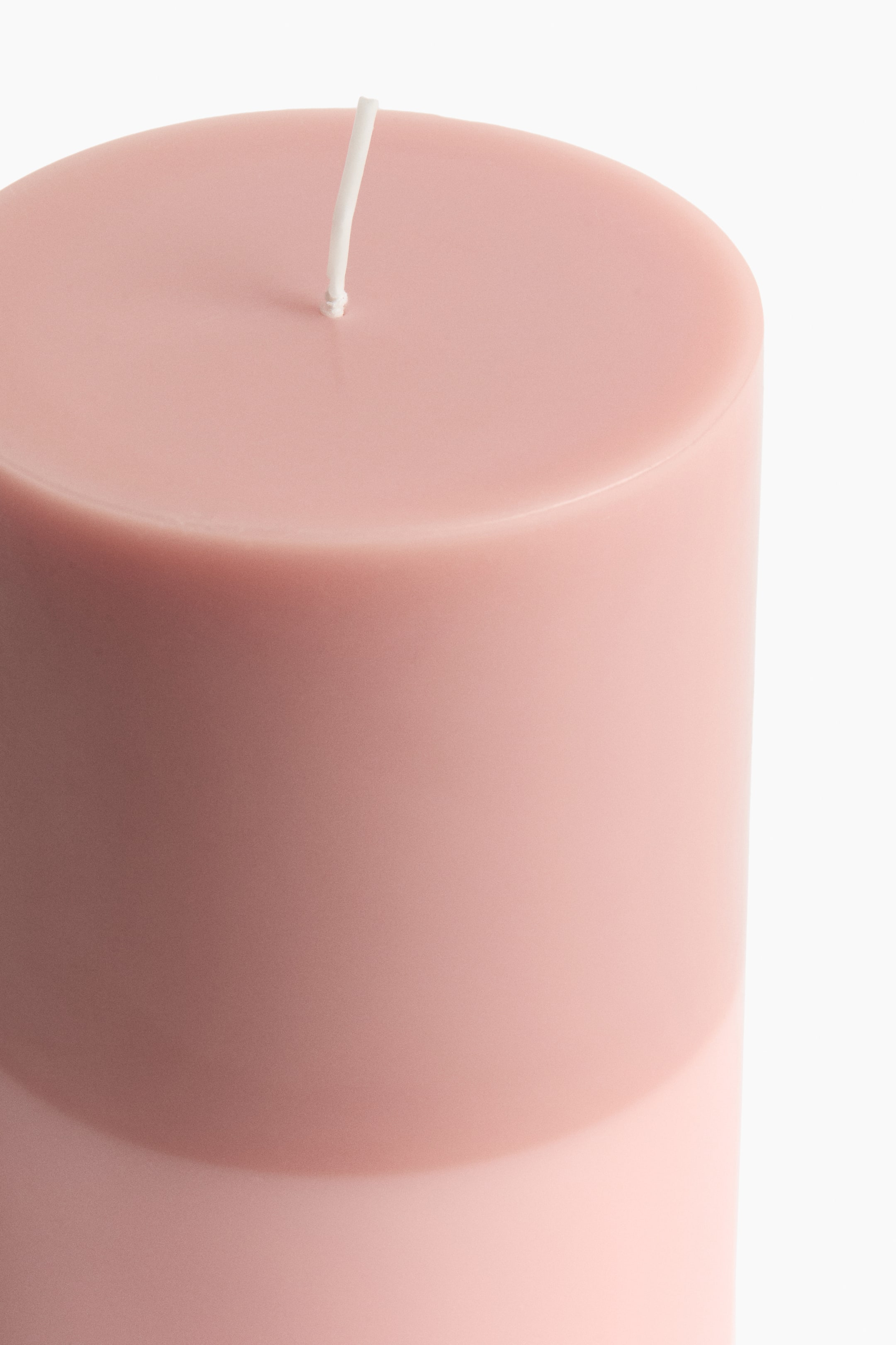 View larger image: Large pillar candle. It is a smooth, cylindrical candle displaying a light pink hue. A single white wick is centrally positioned and standing upright on its flat top surface.