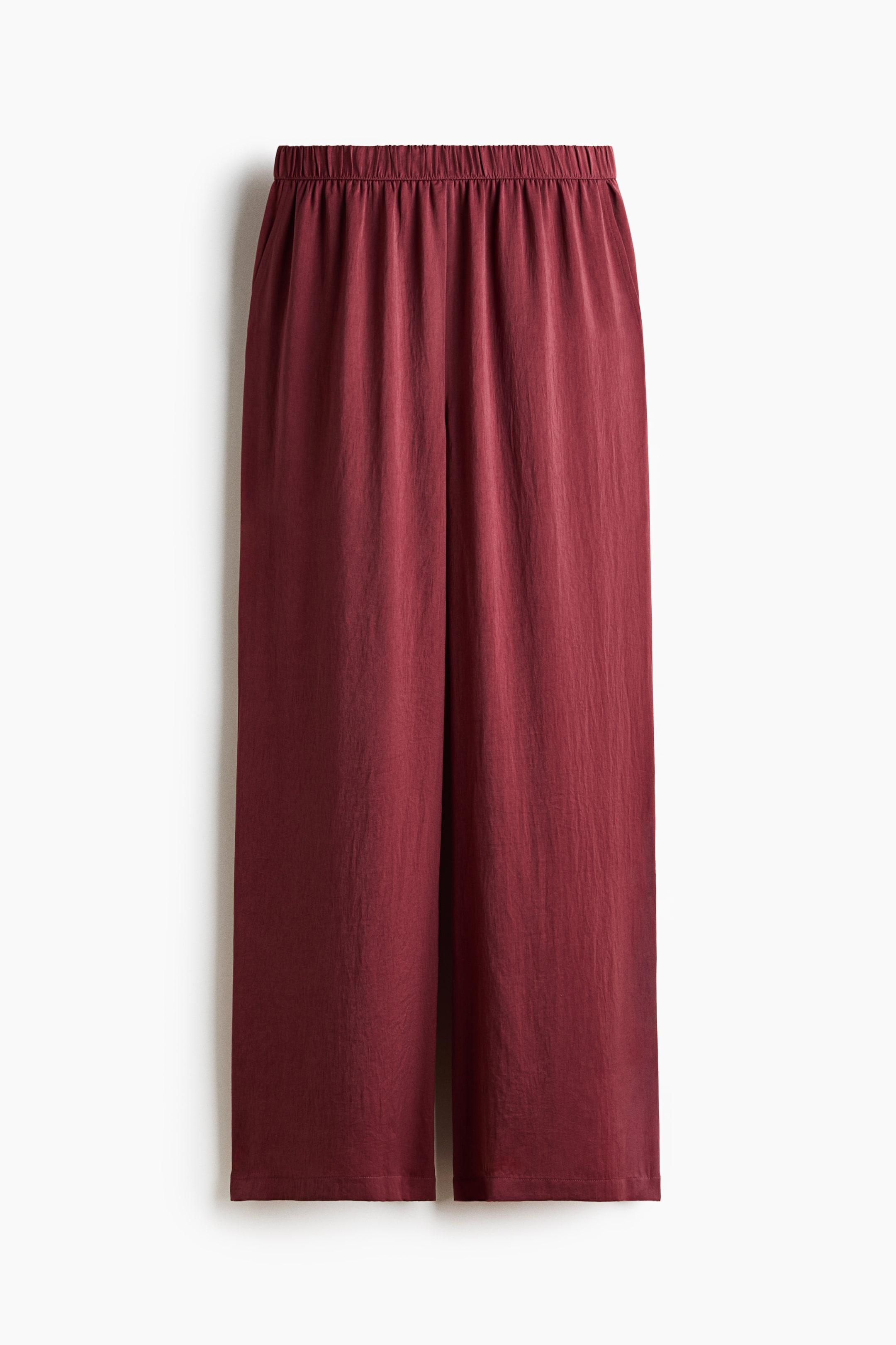 View larger image: The trousers are displayed in a front view, highlighting a subtly crinkled weave with a slight sheen. They feature covered elastic at the waist and diagonal side pockets.