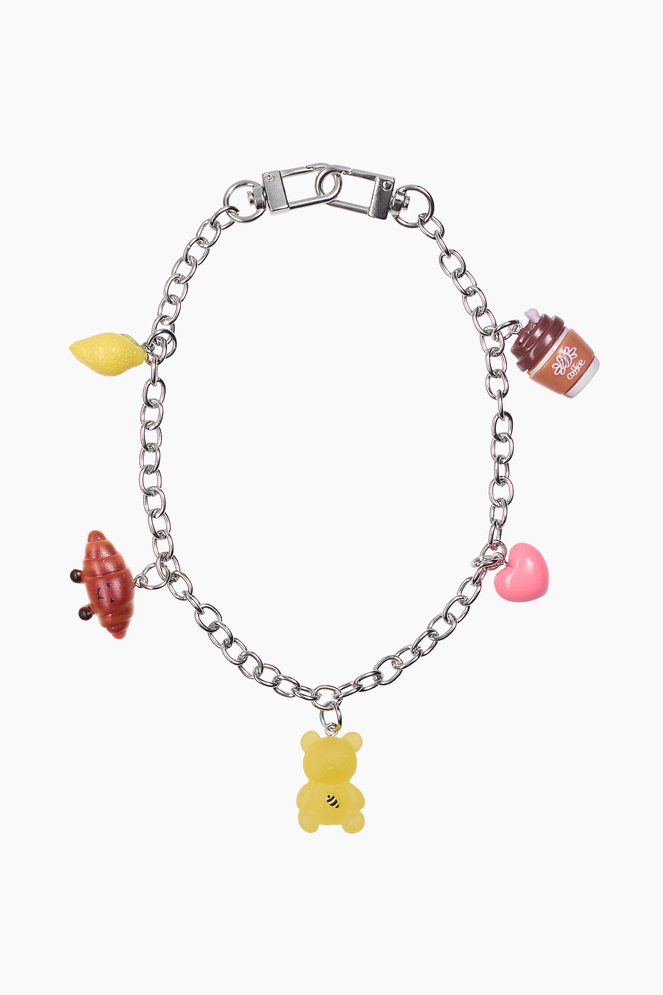 Nagyobb kép megtekintése: A termék egy ezüstszínű charm-karkötő, elölről bemutatva. A láncon öt charm található: egy sárga citrom, egy barna croissant, egy sárga gumimaci fekete méhecske mintával, egy rózsaszín szív és egy barna kávéscsésze, amelyen 'coffee' felirat olvasható.