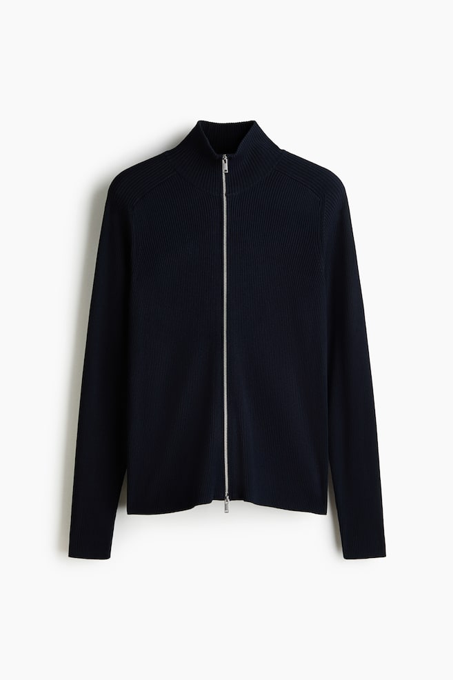 A navy blue ribbed knit full-zip sweater is presenting its front, featuring a stand-up collar, long sleeves with ribbed cuffs, a ribbed hem, and a silver-toned zipper. - 1