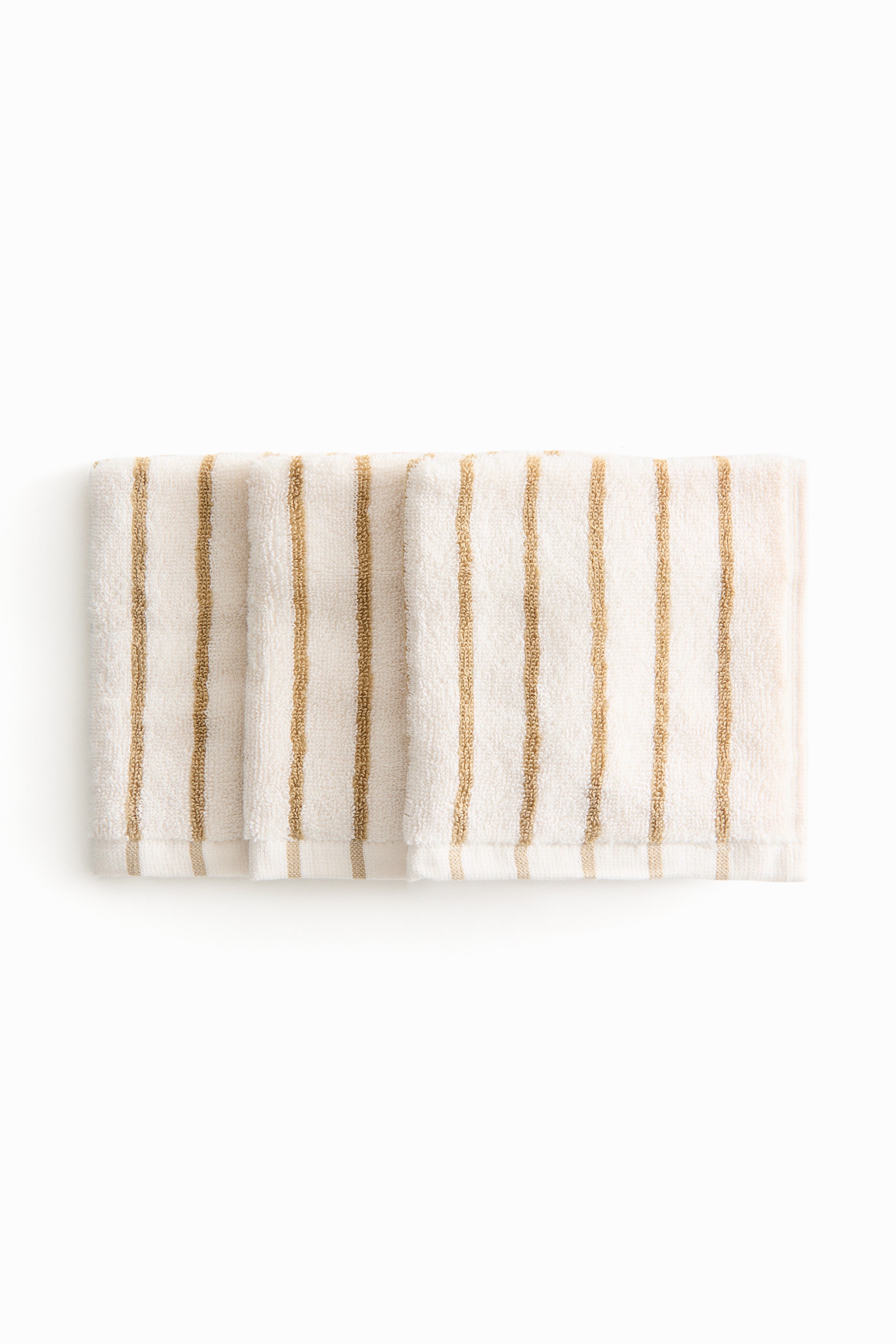 View larger image: Three terry cloth towels are neatly arranged side by side, showcasing an off-white hue with vertical tan stripes.