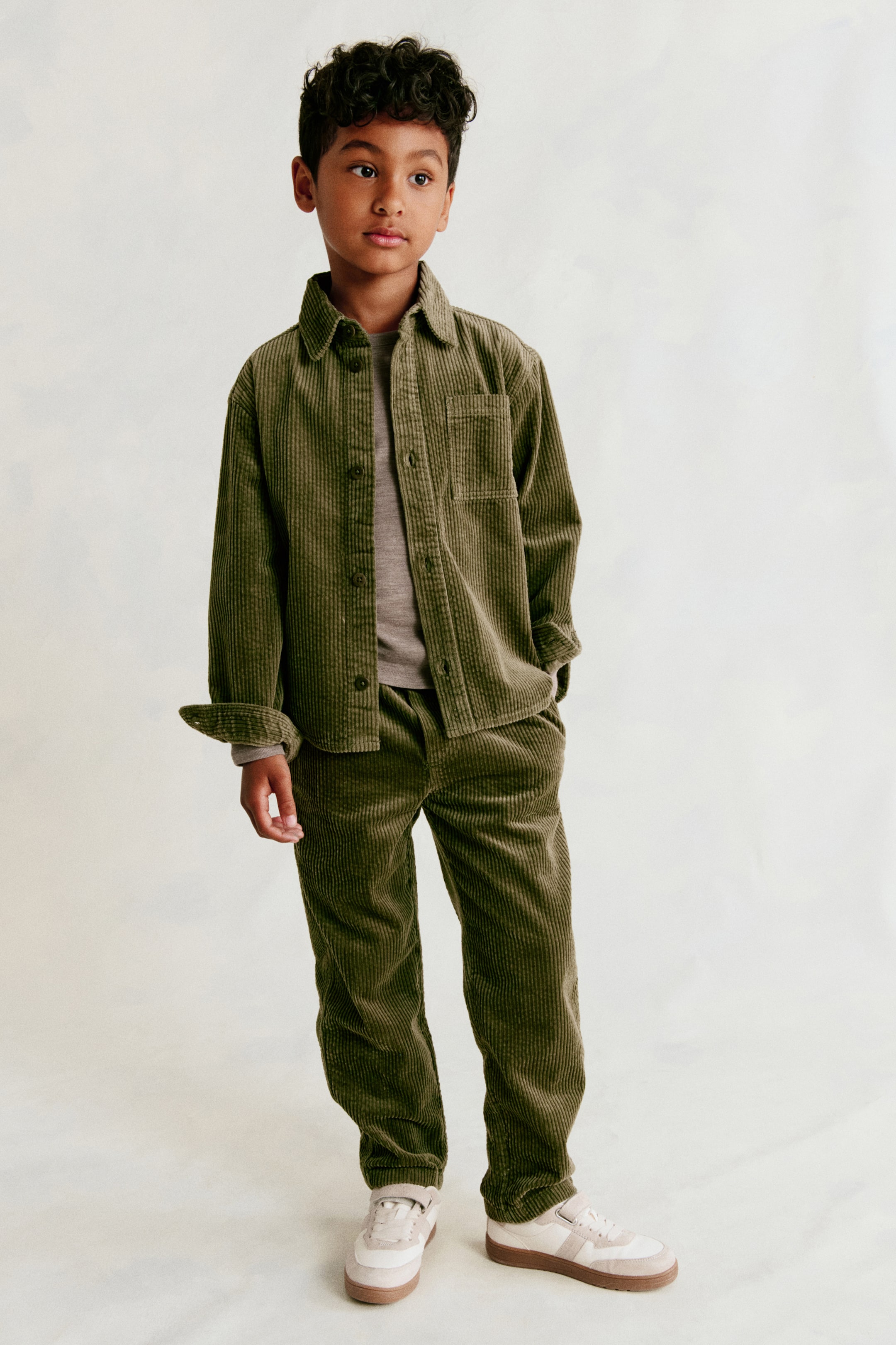View larger image: The H&M Adorables trousers showcase a dark green corduroy fabric with a prominent ribbed texture. They are presented from the front, displaying a relaxed, straight-leg fit.
