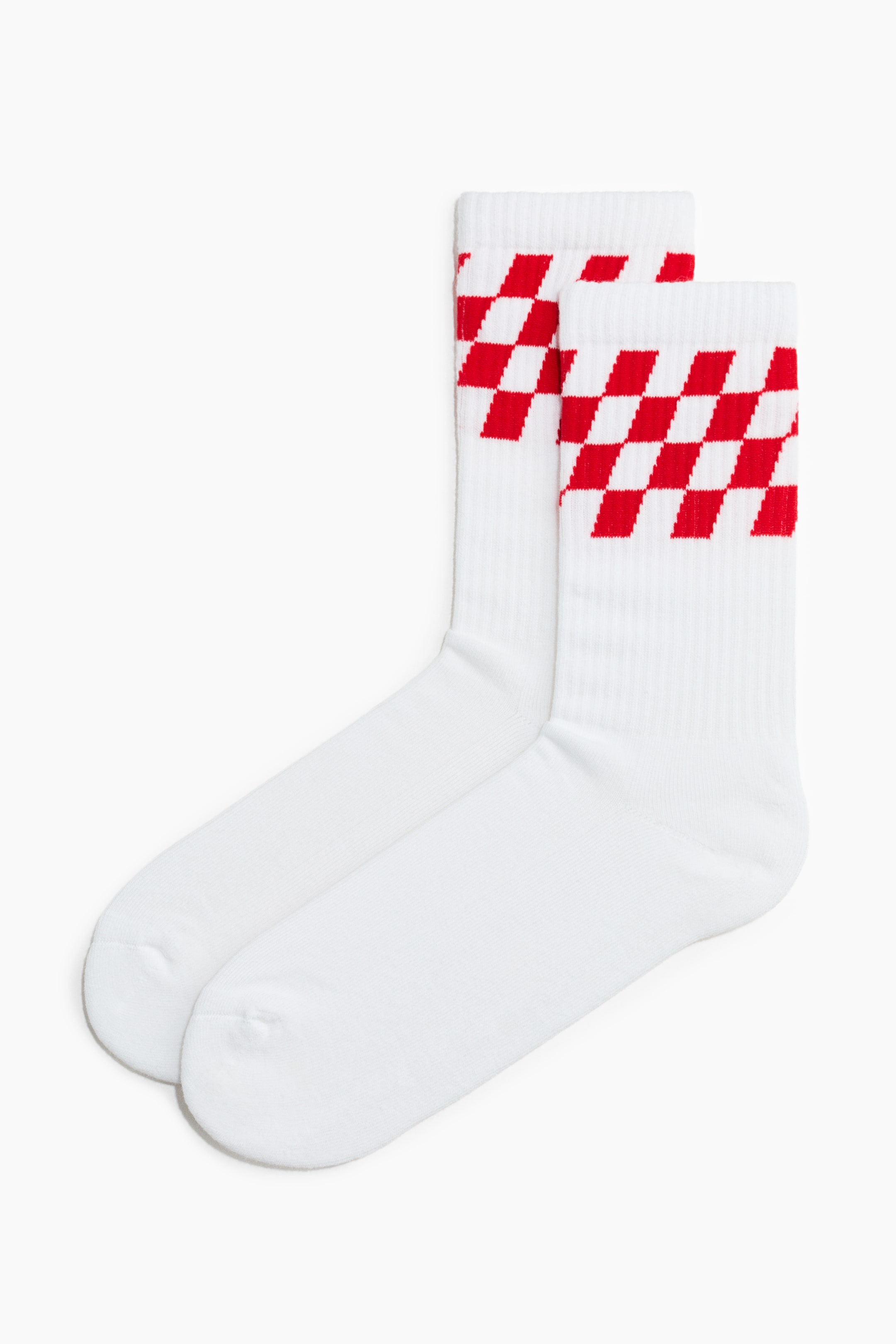 הצגת תמונה גדולה יותר: שתי גרבי ספורט לבנות מונחות שטוחות, על כל אחת מהן מופיע דפוס משבצות אדום ולבן מסביב לצווארון המחורץ.