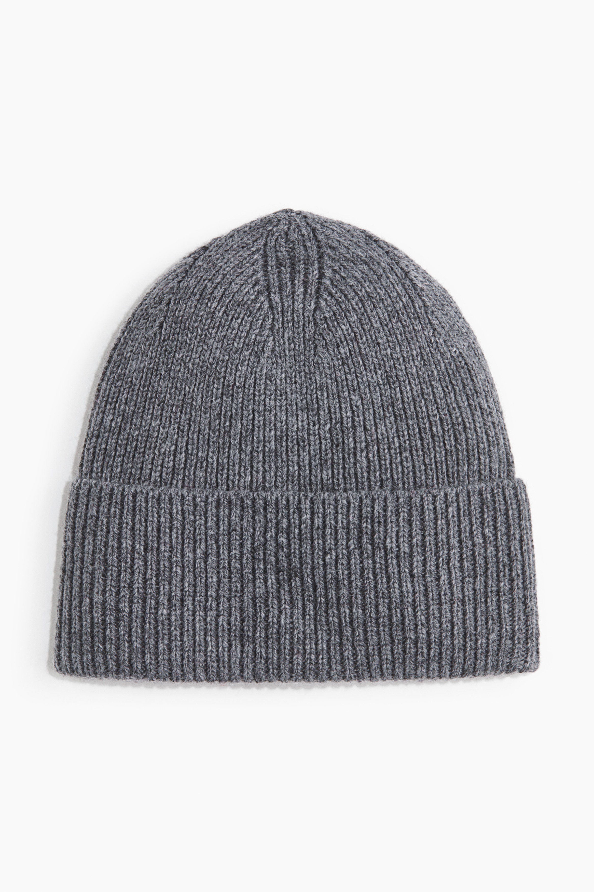 A grey beanie in a soft rib-knit featuring a wide turn-up hem is being worn by the model. The beanie is styled with a dark grey collared coat layered over a matching high-neck top.